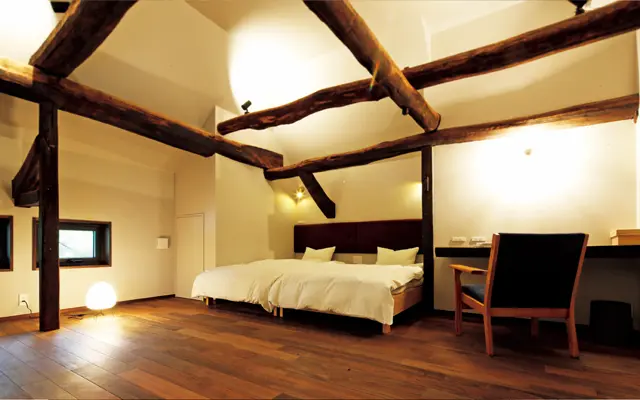 立派な欅の梁を生かしたベッドルーム。天然素材の寝具で知られる「石田屋」のセミダブルベッドを導入