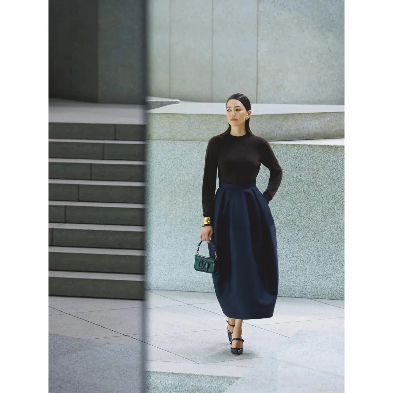 ブラウン×ネイビーのコンサバな配色は、構築的なコクーンシルエットでモードに魅せる。気温19℃