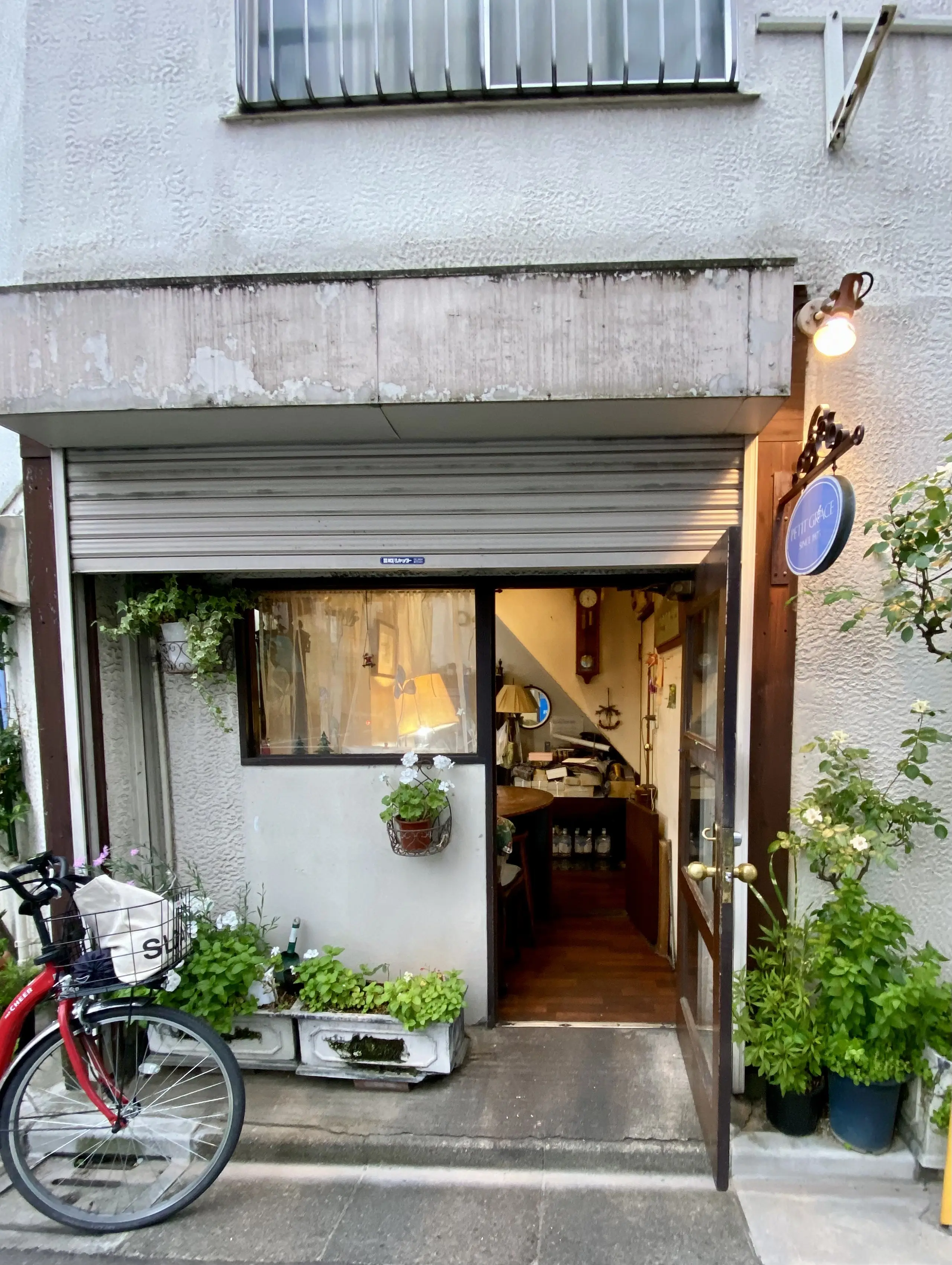 荻窪の住宅街にひっそりと佇むプチグレースの外観。木の扉と小さな植栽が印象的