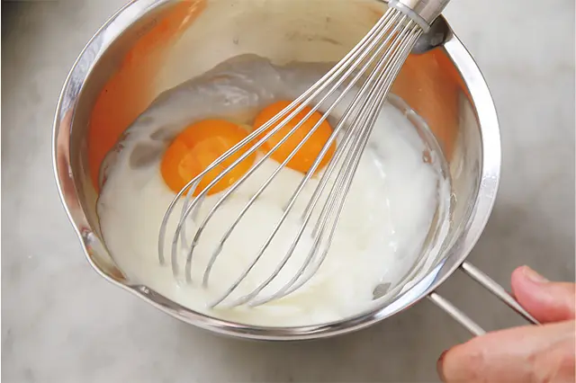 ボウルごと中火にかけ、クリーム状に煮る。一度火からおろし、卵黄を加え混ぜる。