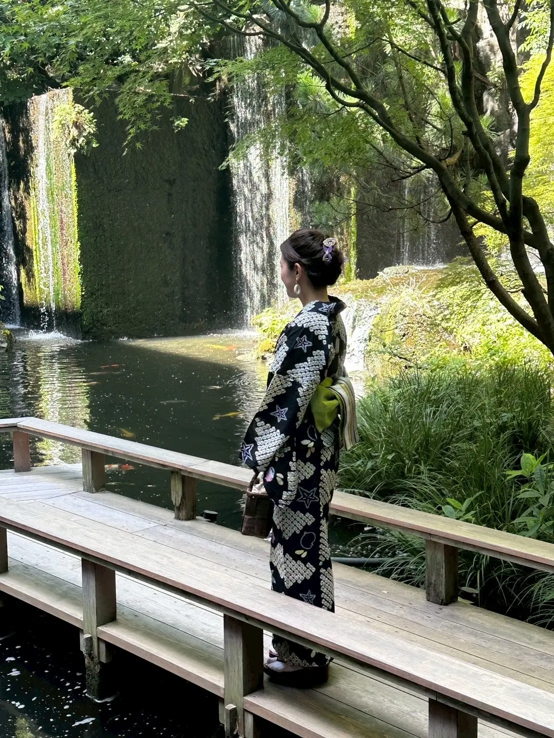 雅叙園の庭園の滝を背景にした後ろ向きの浴衣姿。