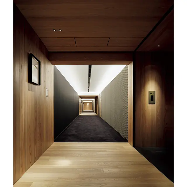 廊下は、真っ  黒な絨毯と天然木とを組み  合わせたデザイン。