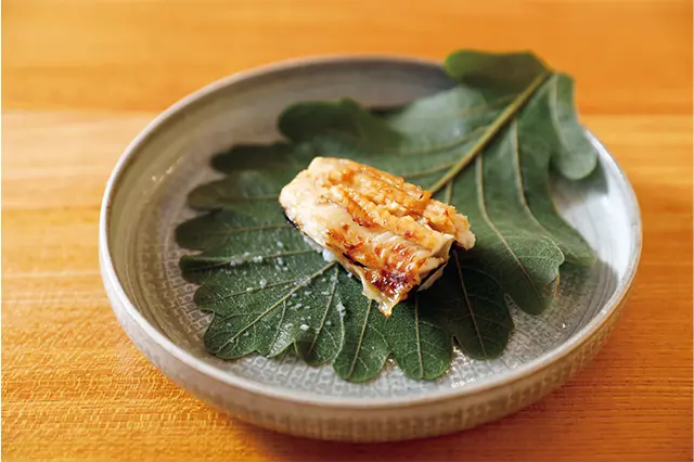 御凌「穴子柏蒸 撥子」。れんこんと もち米を合わせ、穴子と柏の葉でくるんで蒸し寿司に。ばちこが隠 し味に