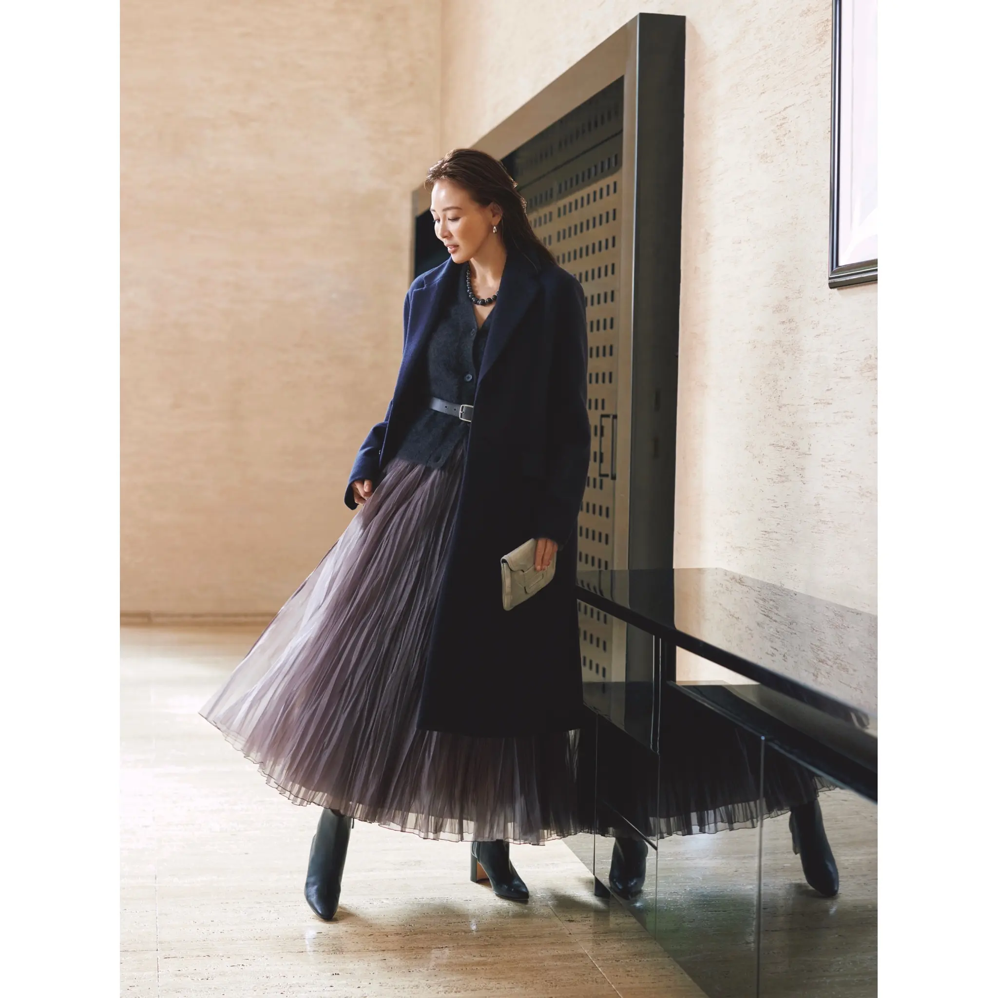 ネイビーのテーラードカラーコートの中に、グレーVネックカーディガンとグレーシフォンスカートを合わせたコーディネート　モデル・SHIHO