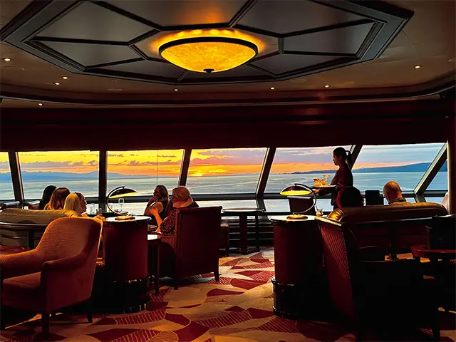 船上から眺める夕日は、ひときわロマン ティック。デッキ10の船首にある「コモドアー・クラブ」は、 眺望抜群のラウンジ