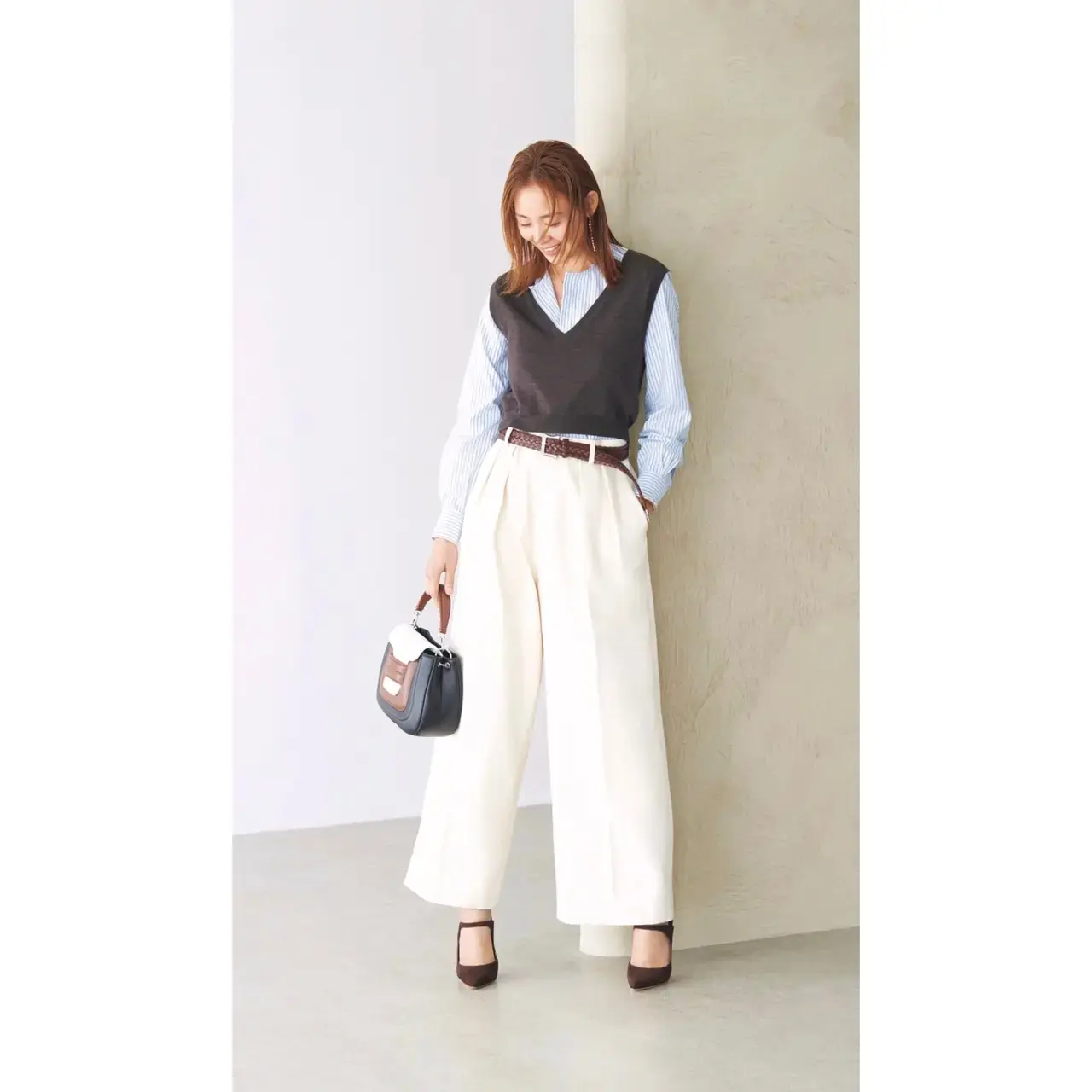 淡色コーデをブラウンのニットベストで引き締めるバランスがおしゃれ。