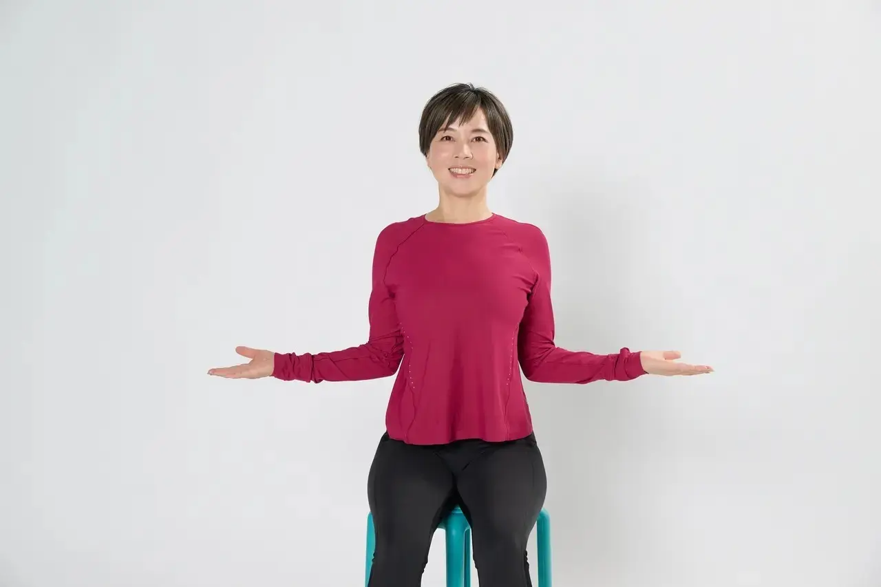 ①椅子に座って背筋を伸ばし、両肘を90度に曲げて脇をしっかりと締め、手のひらを上に向ける。そのまま肘から下を真横に開く。この肘の開き閉じを2回繰り返す。