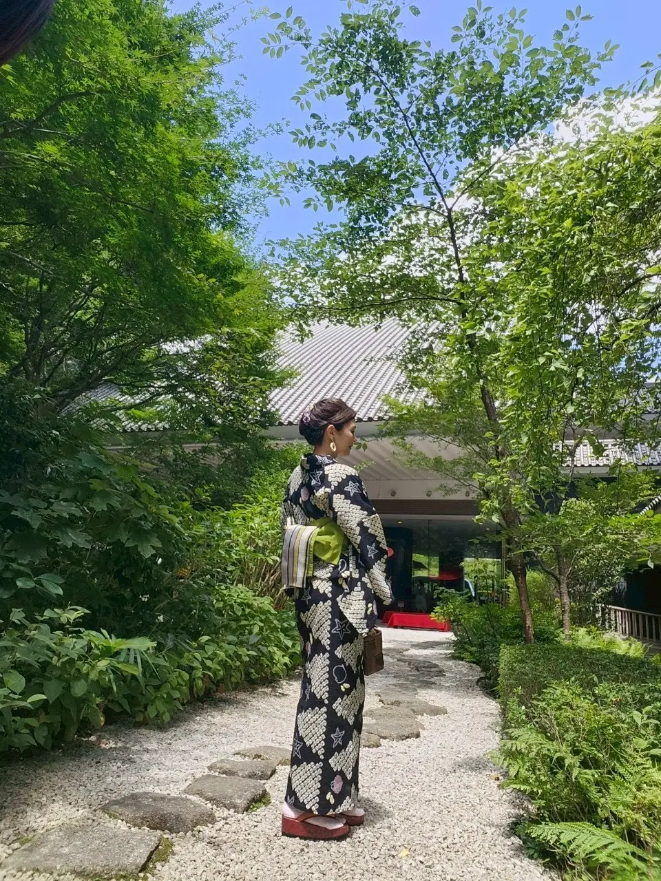 雅叙園中庭に立つ浴衣姿の女性の写真。緑とのコントラストが美しい