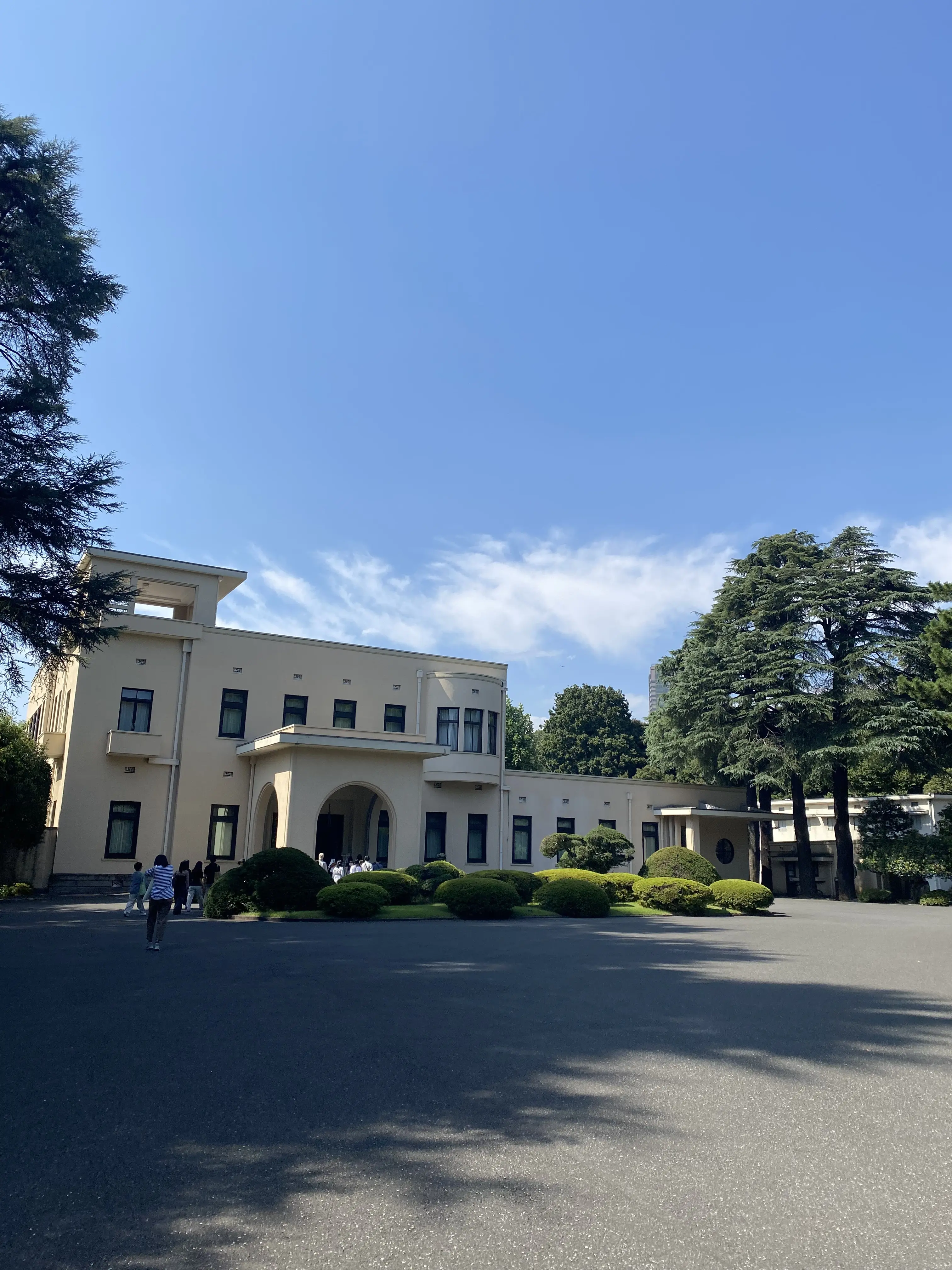 東京都庭園美術館の外観。アール・デコ様式の優雅な邸宅が広い前庭に佇み、青空と緑に包まれている。