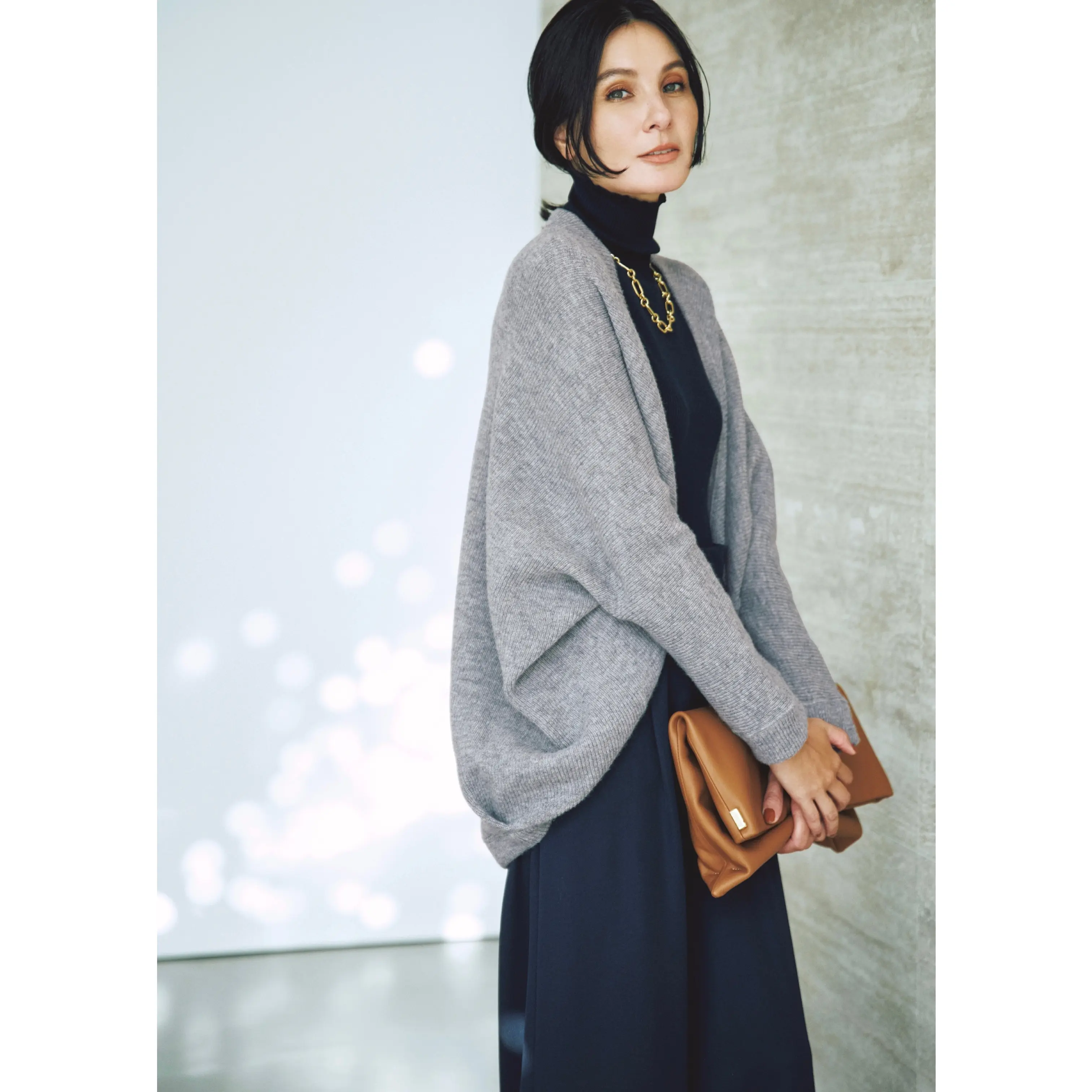 グレーボレロカーディガンと黒タートルニットとタックパンツを合わせたコーディネート　モデル・田沢美亜