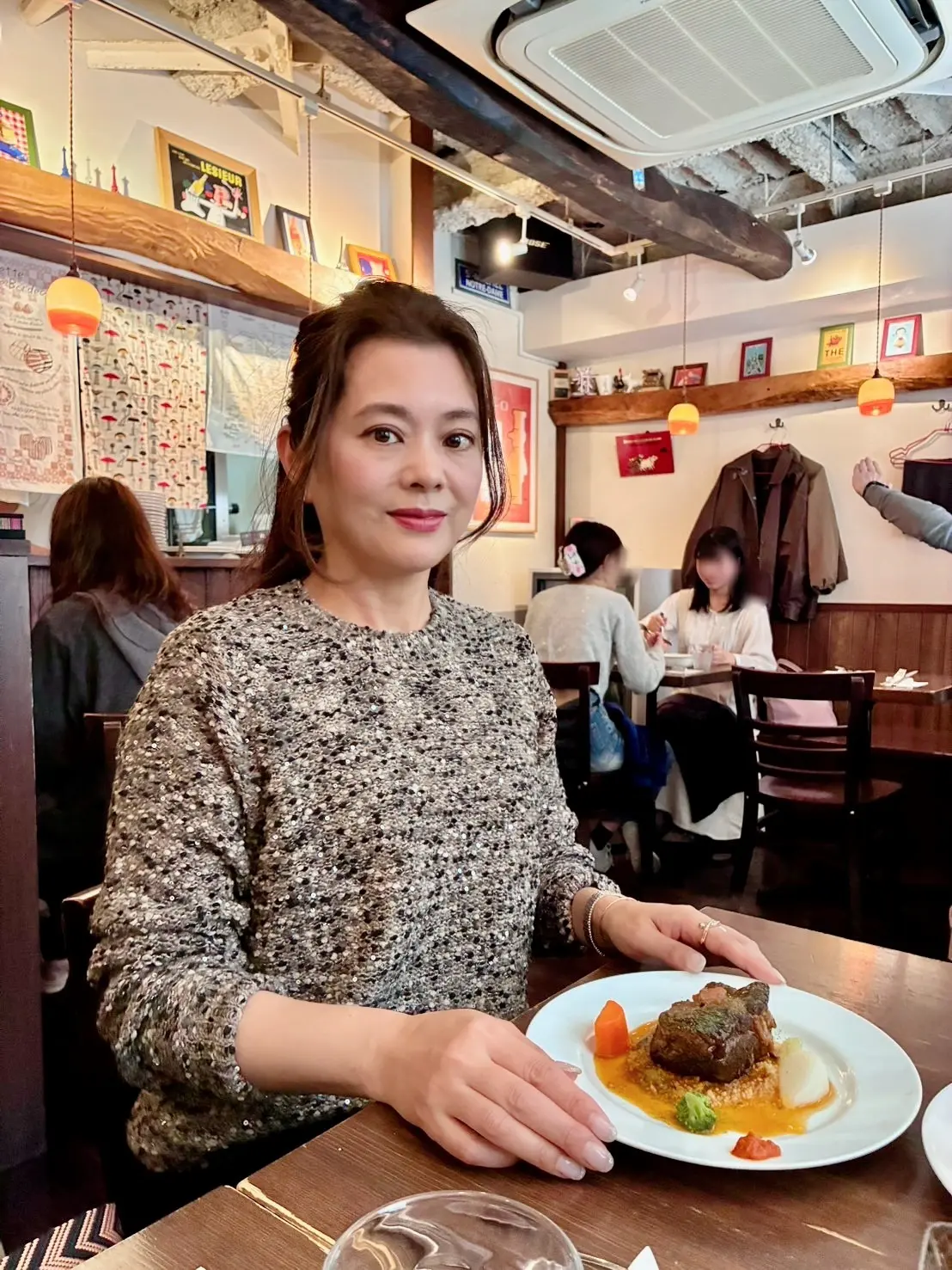 西早稲田の人気ビストロ「フランス食堂 montée（モンテ）」店内でランチを楽しむ女性｜早稲田ランチでおすすめのフレンチ・牛肉の赤ワイン煮込みを味わう様子｜予約必須の隠れ家レストラン