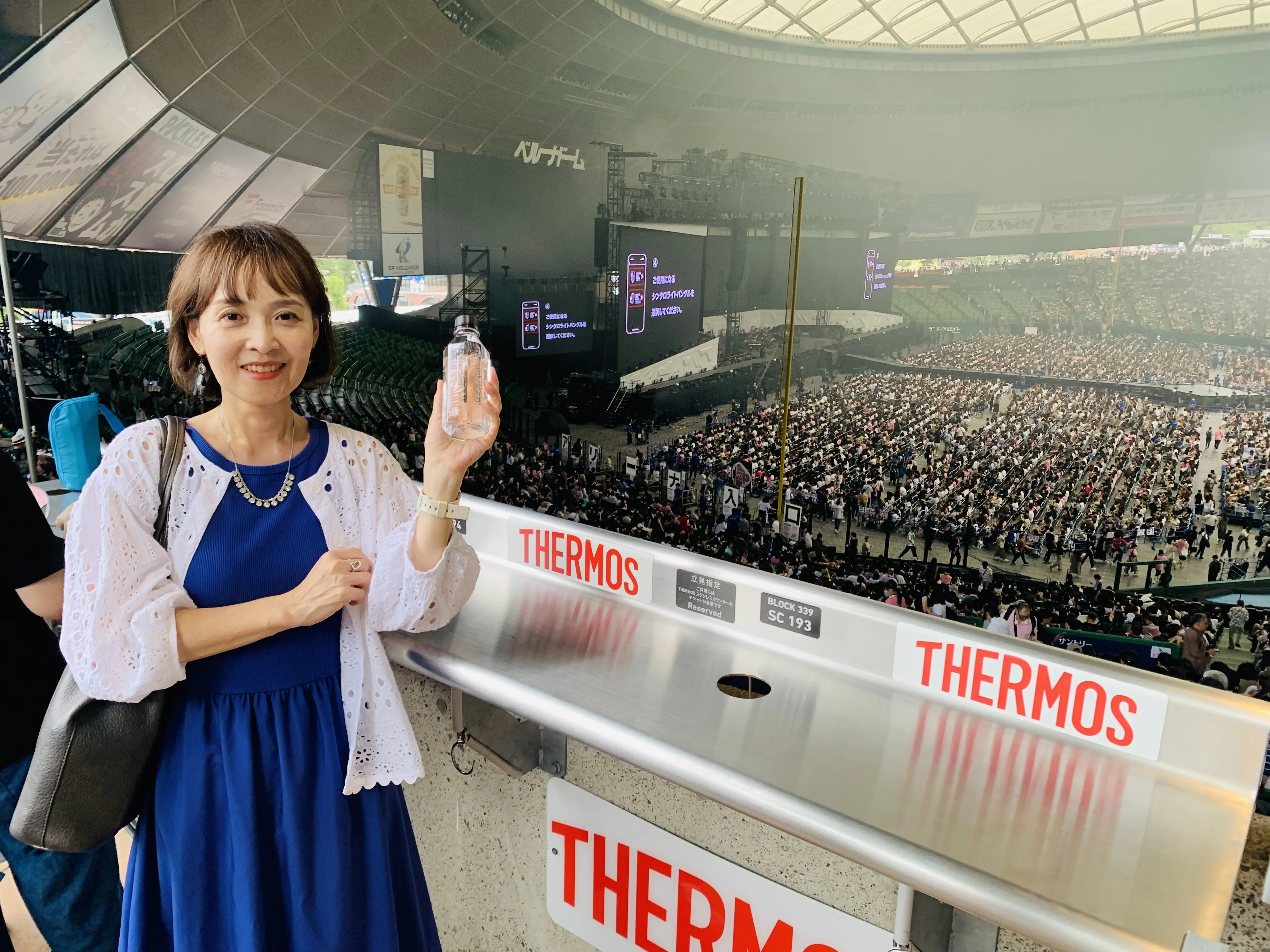ライブ開始直前のベルーナドームで写真撮影をする女性