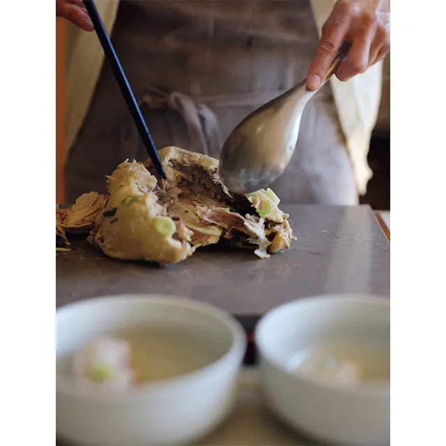 煮上がった丸鶏はしっとりと軟らかく、お箸とスプーンだ けでホロッと簡単にくずせる。丸鶏ならではの味わい深さ
