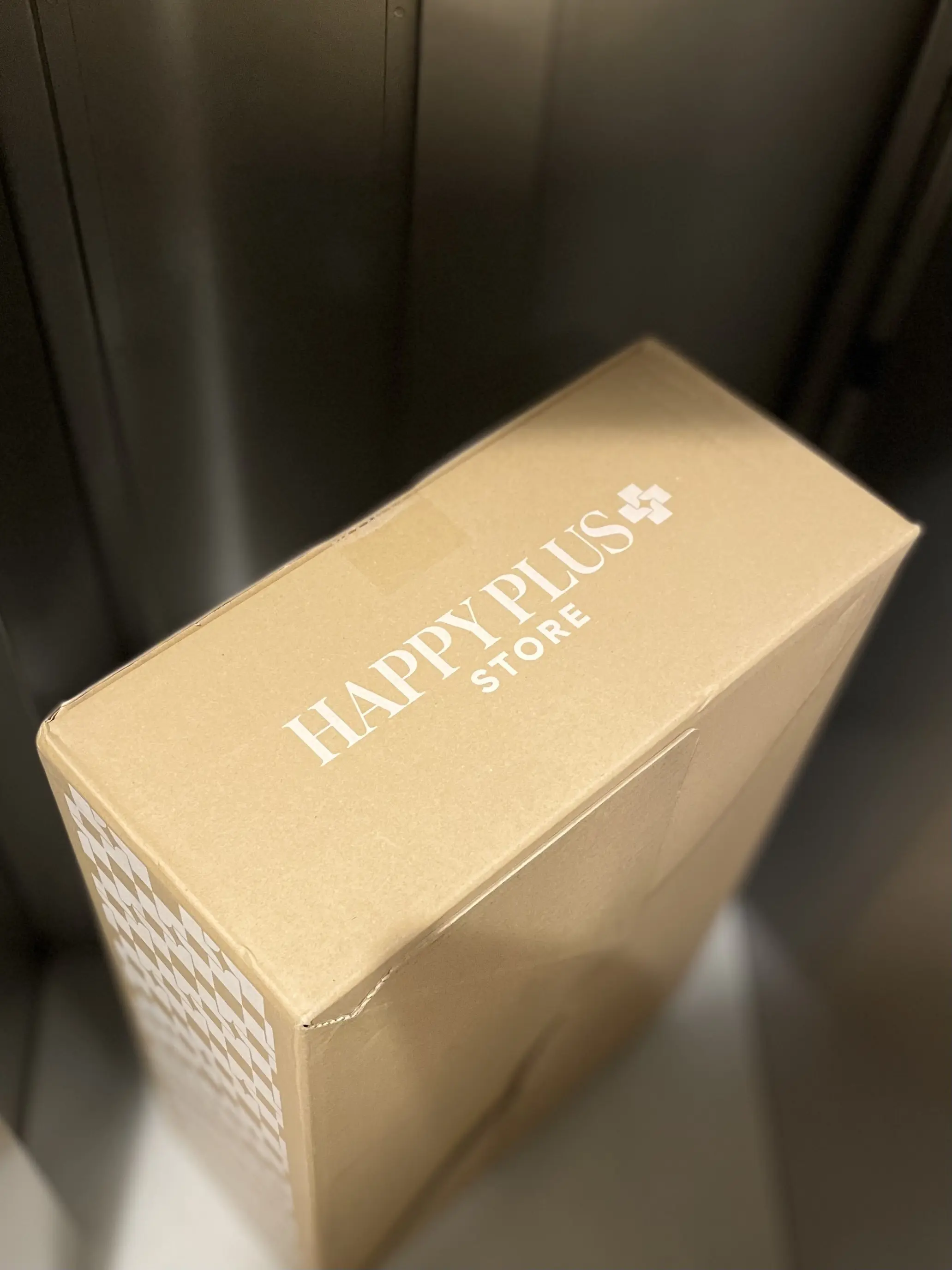 宅配ロッカーに届いたHAPPY PLUSの段ボール箱