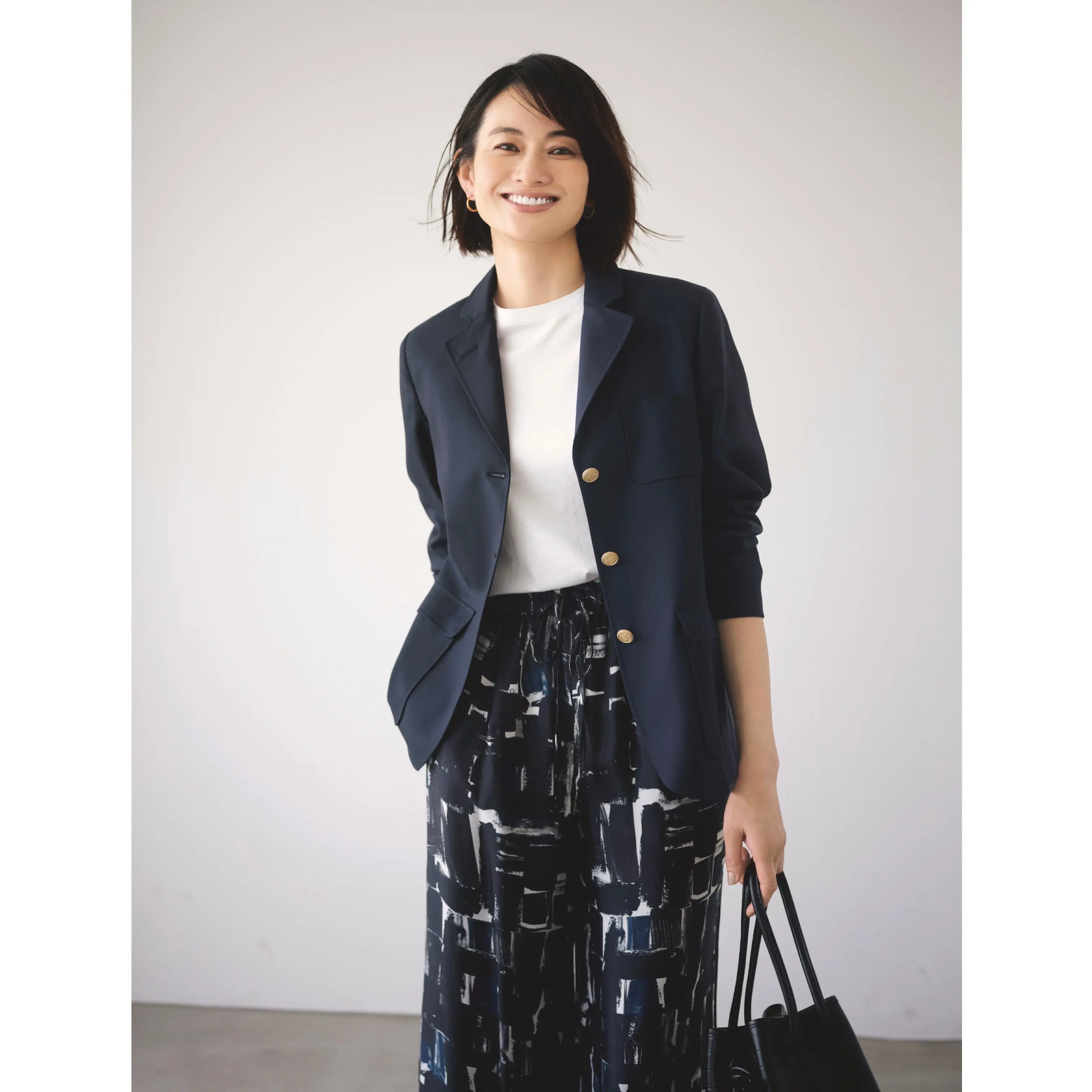 白カットソーとネイビーペイント柄パンツにネイビージャケットをはおったコーディネート　モデル・渡辺佳子