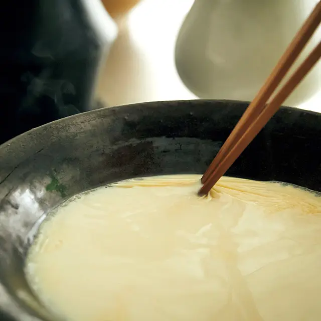 豆乳を温めるときは強 火厳禁。必ず弱火でゆ っくり温めること。膜 が張ったら、菜箸の先 で破って混ぜ込みなが らさらに温める。