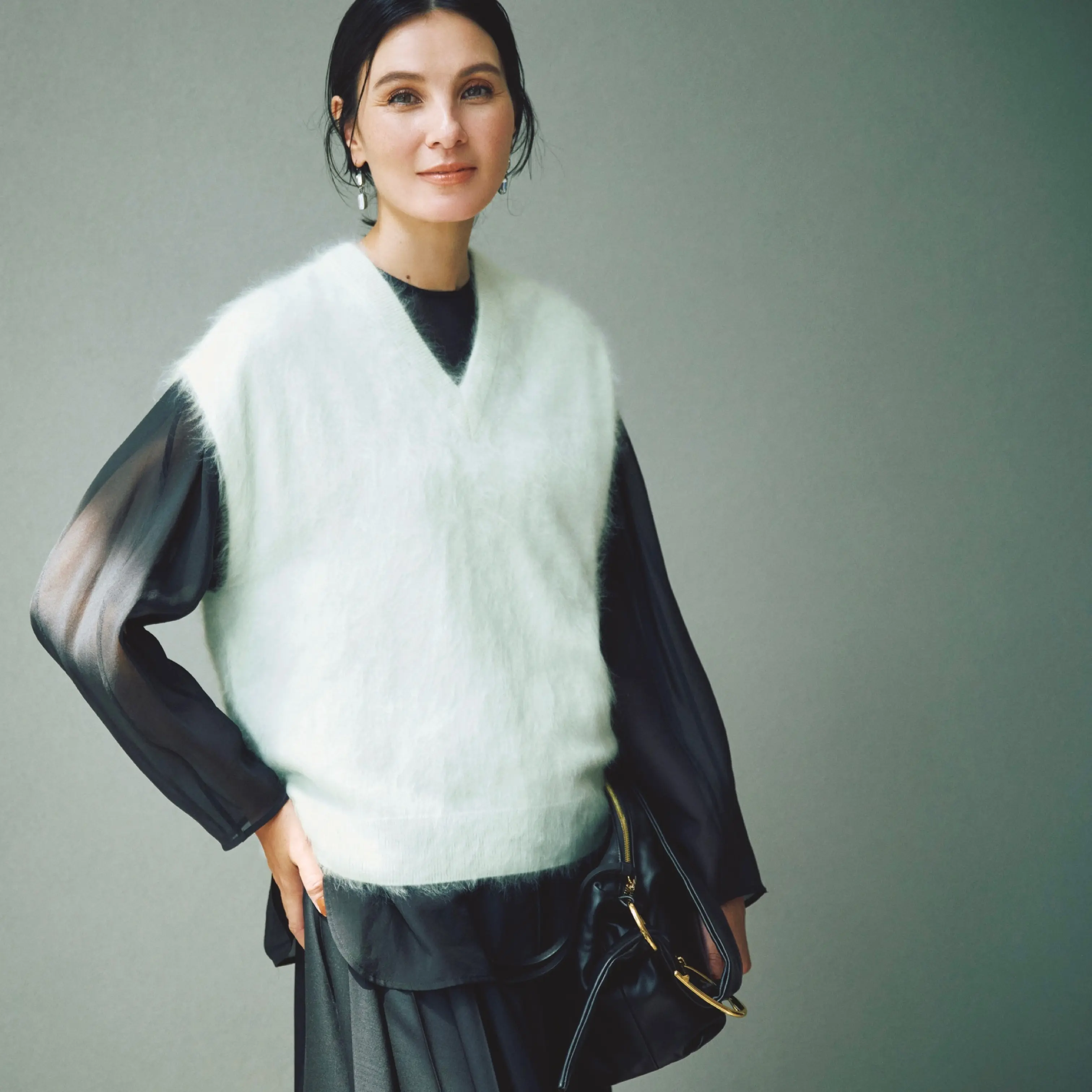 ダークグレーシアーブラウスに白モヘアニットベストを重ね、プリーツスカートを合わせたコーディネート　モデル・田沢美亜