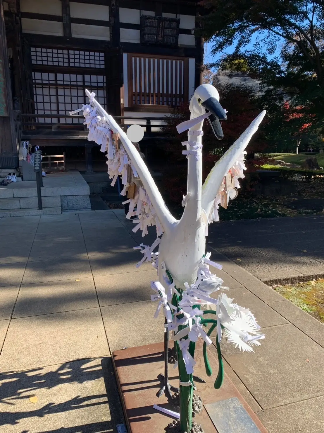 おみくじが沢山結ばれていり白鳥の像