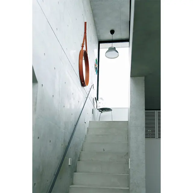 リビングからバルコニーへ上がる階段。堅 牢でシンプルなコンクリート造の内装も気に入っている