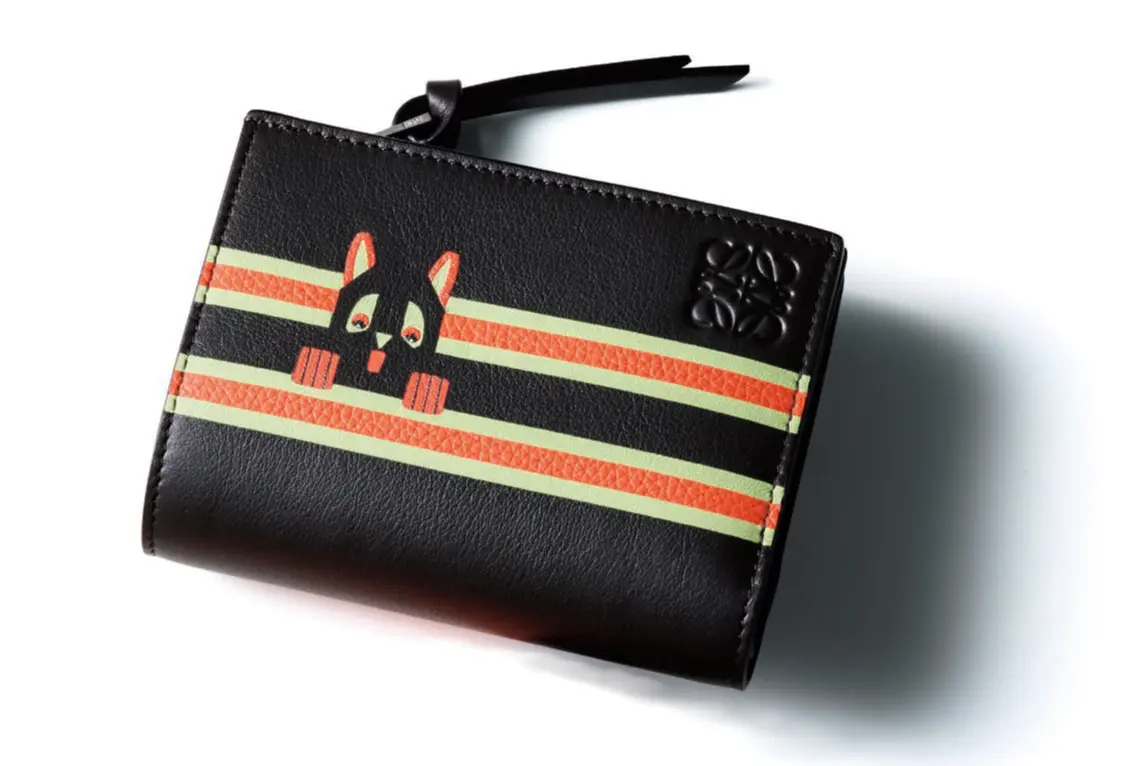 イギリス人アーティストのルイス・ウェインが描く、猫に着想を得たモダンなデザインを引き立てるのは オレンジの色使い。小ぶりながらも実用的な機能は申しぶんなし。札入れ1、小銭入れ1、カード挿し6、ポケット3。二つ折りウォ レット（8.5×11.4×3）￥115,500／ロエベ ジャパン クライアントサービス（ロエベ）