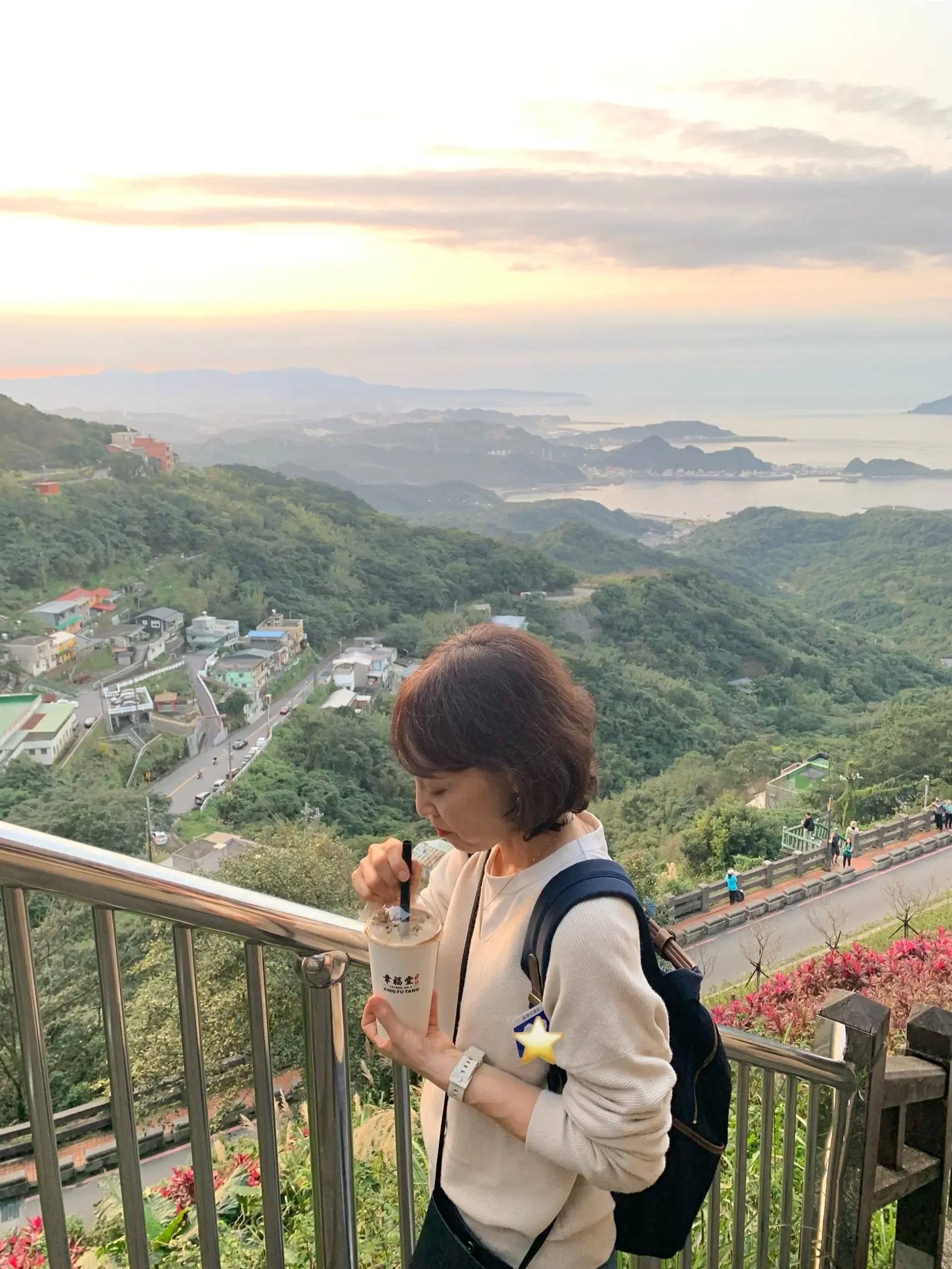 東シナ海を背景にタピオカドリンクを飲む女性