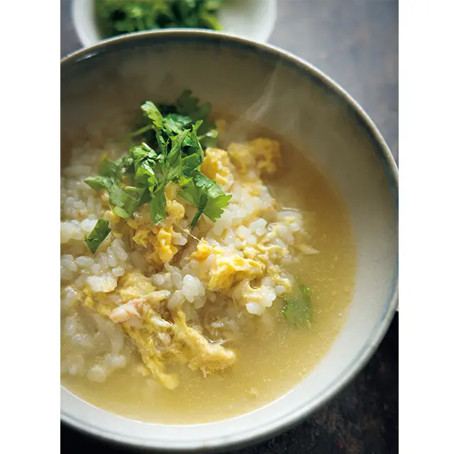 締めはカニ雑炊！ 残ったスープに甲羅の カニ肉や味噌、ごはんを入れ、甲羅をのせる。 煮立ったら溶き卵を流し入れて火を通し、 刻んだせり少々を加えていただく。