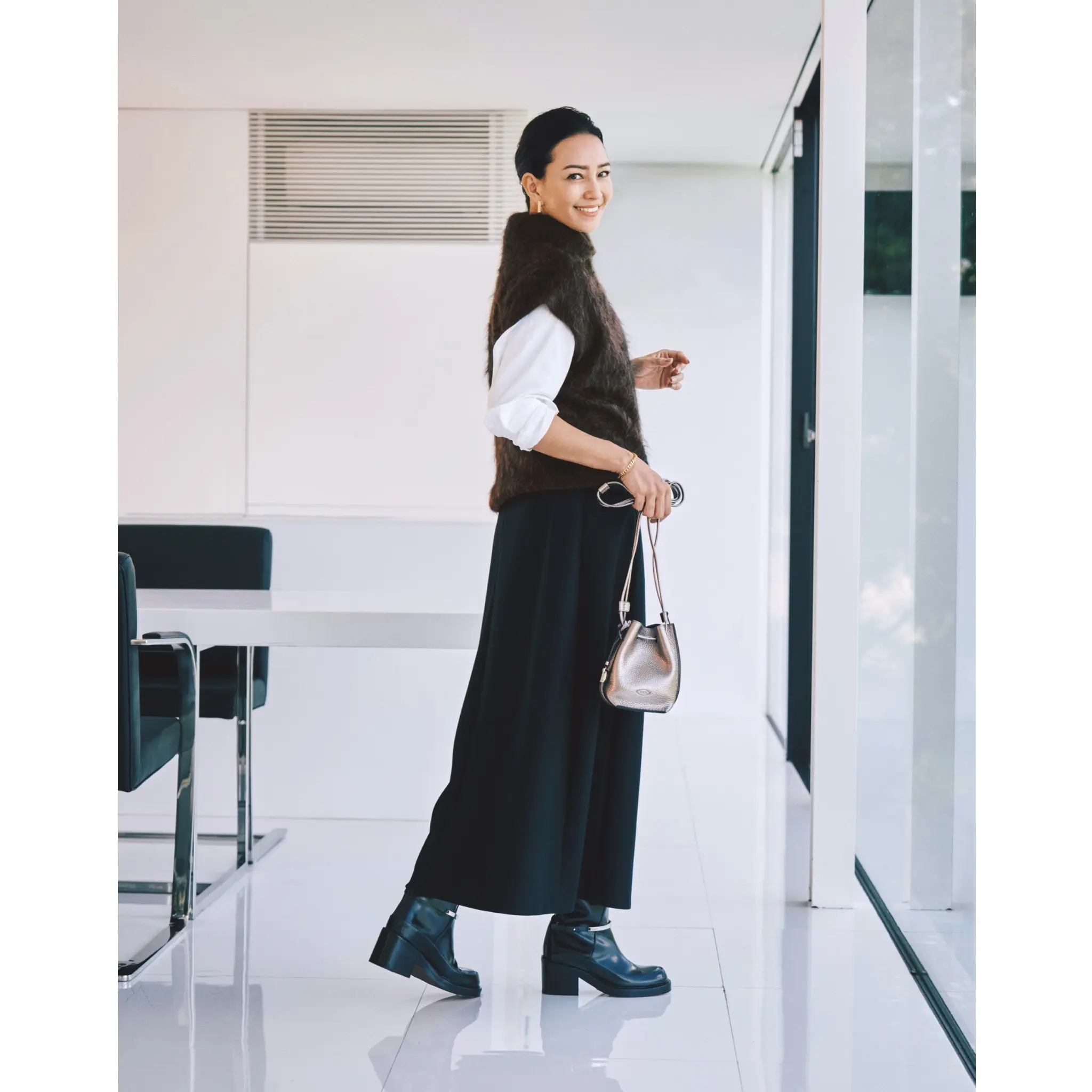 白シャツにブラウンシャギーニットのハイネックベストを重ね、黒ワイドパンツ合わせたコーディネート　モデル・RINA