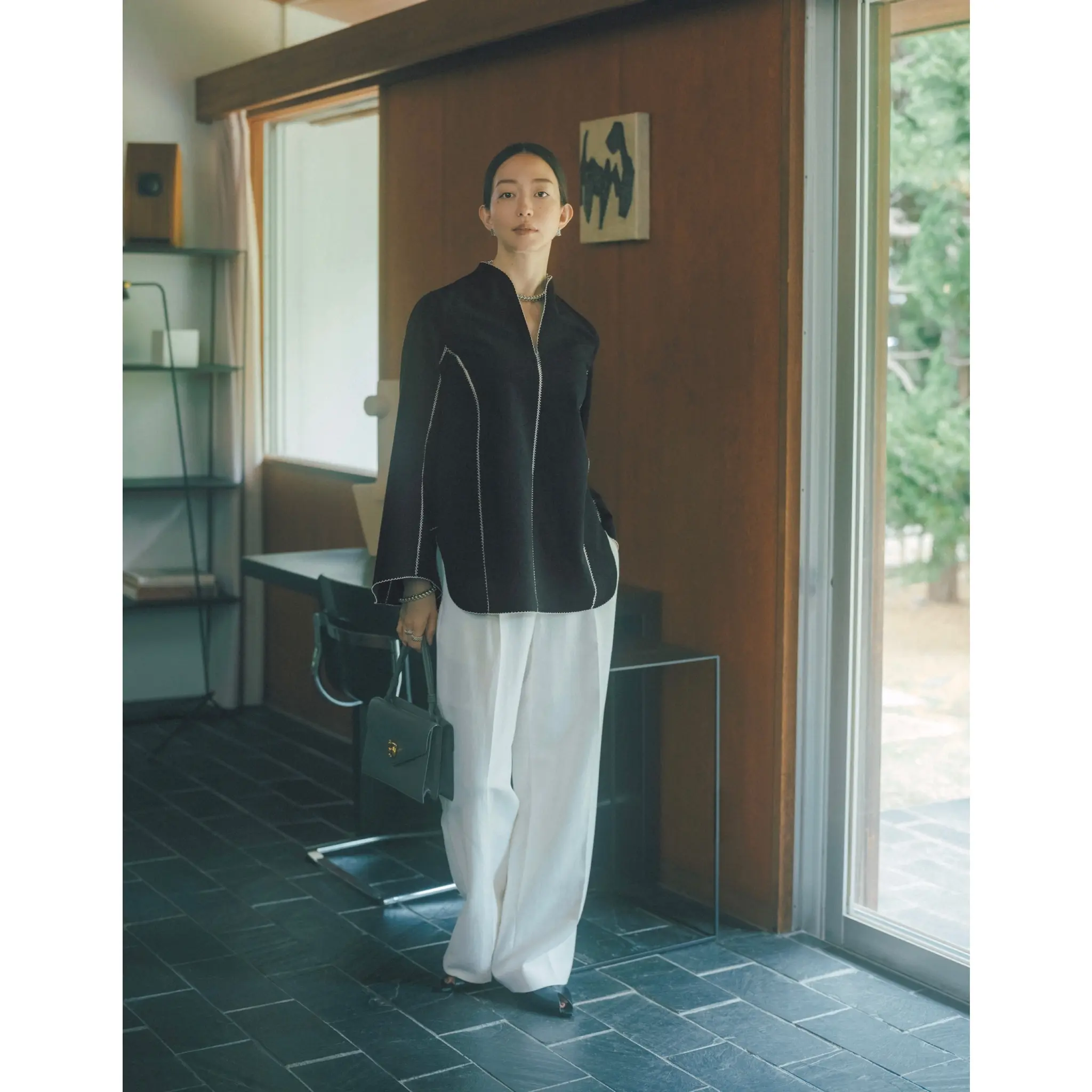 白のライン入りデザインの黒ブラウスに白パンツを合わせたコーディネート　モデル・松島花