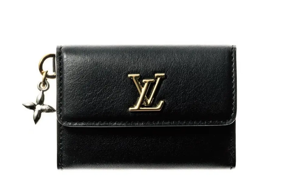 気品高いたたずまいにモノグラム・フラワーのチャームをあしらった、大人好み の洒脱なデザイン。万能な黒はデイリーもオケージョンもおまかせ。札入れ1、小銭入れ1、 カード挿し3。三つ折りウォレット（7×10×3）￥96,800／ルイ・ヴィトン クライアント ービス（ルイ・ヴィトン）