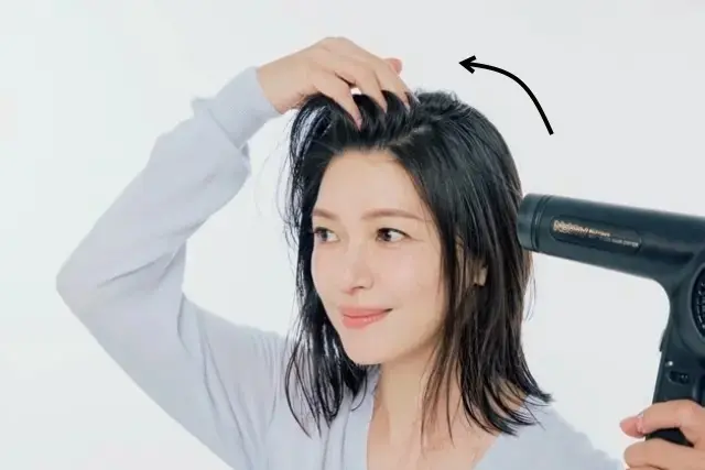 1.いつもの分け目を覆うように髪を倒し、根元を乾かす