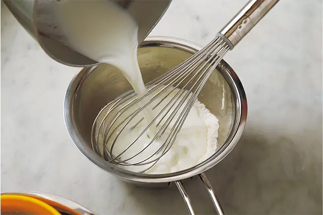 ボウルに薄力粉と砂糖を入れ泡立て器でよく混ぜ、ここに50℃くらいに温めた牛乳を加え、泡立て器でよく混ぜる。