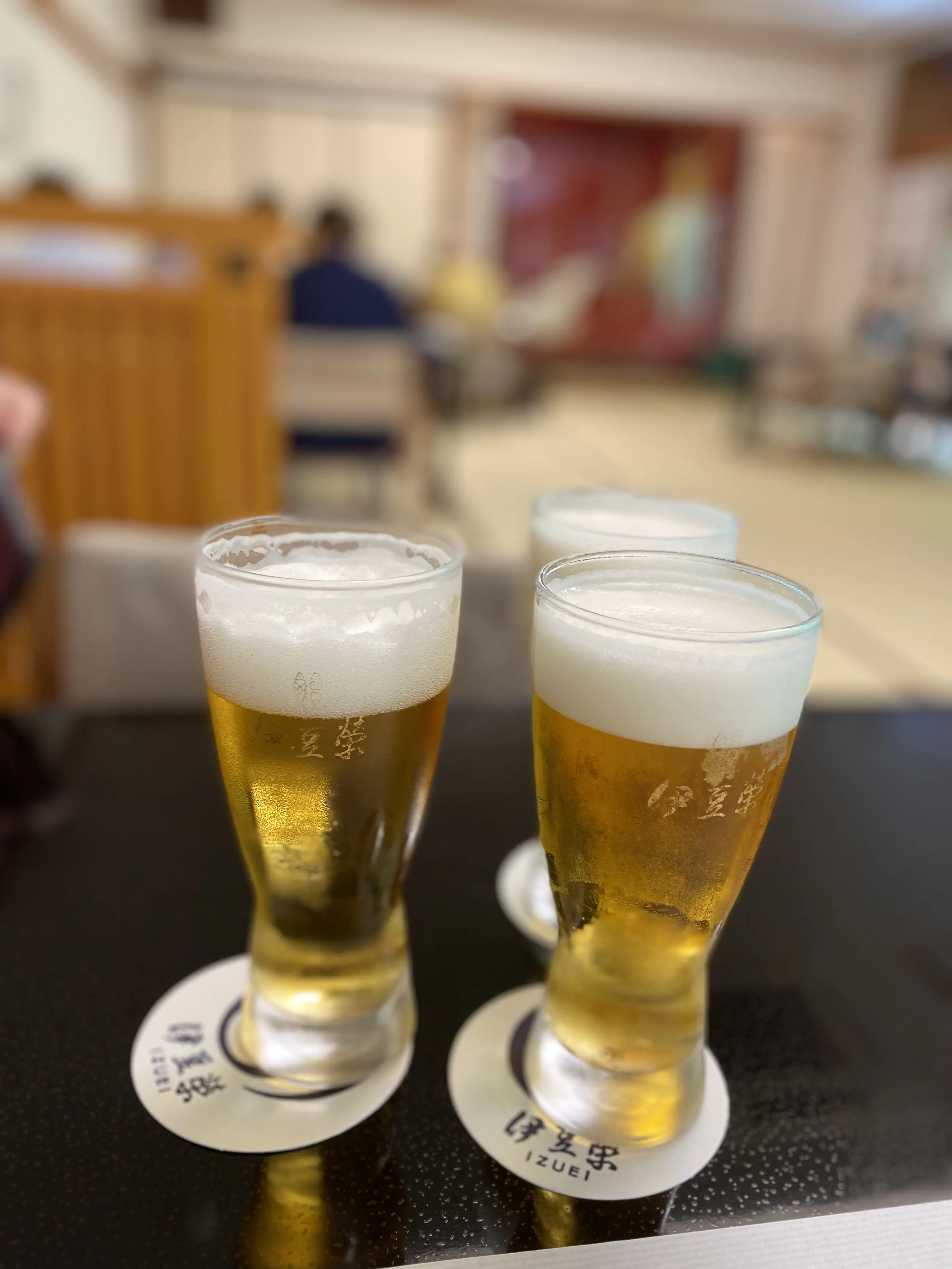 伊豆栄のロゴ入りグラスで提供される生ビール