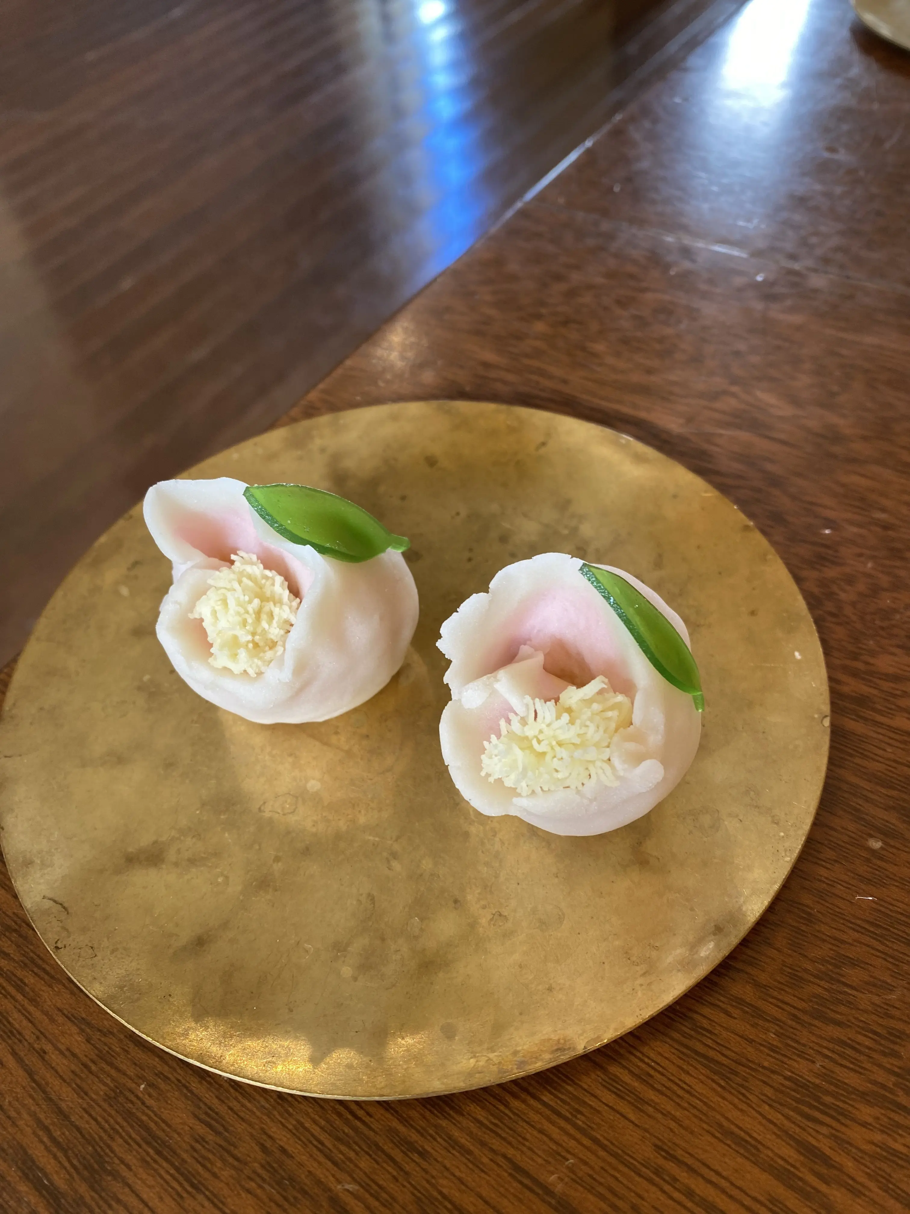 完成した上生菓子「こかたし（山茶花）」2つを金皿に盛り付けた写真。