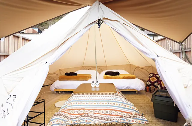 セミダブルベッドを2台設置したテント。冬場はこたつが置かれる。ほかにキャビン型宿泊施設も