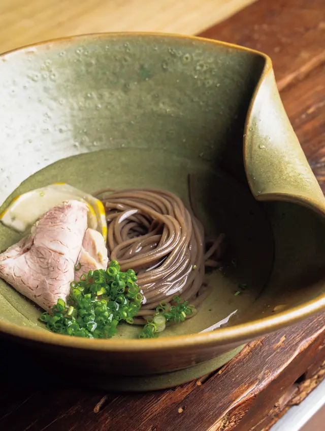 メミル（そば粉麵） を使用した、ゆで豚をのせた冷麵。冷ました豚肉を使うのも北朝鮮の食文化から