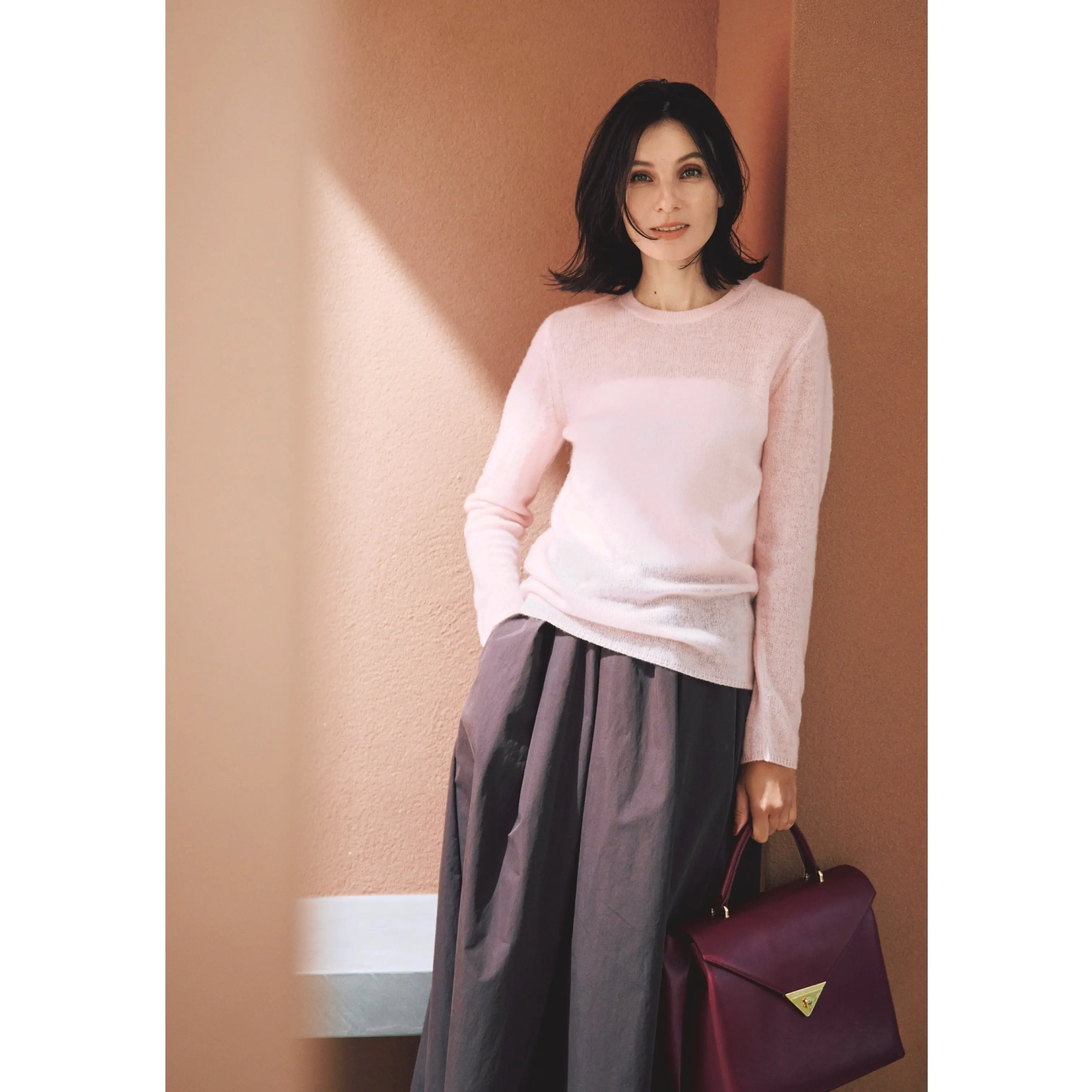 ライトピンクのシアーニットにブラウンのスカートを合わせたコーディネート　モデル・田沢美亜