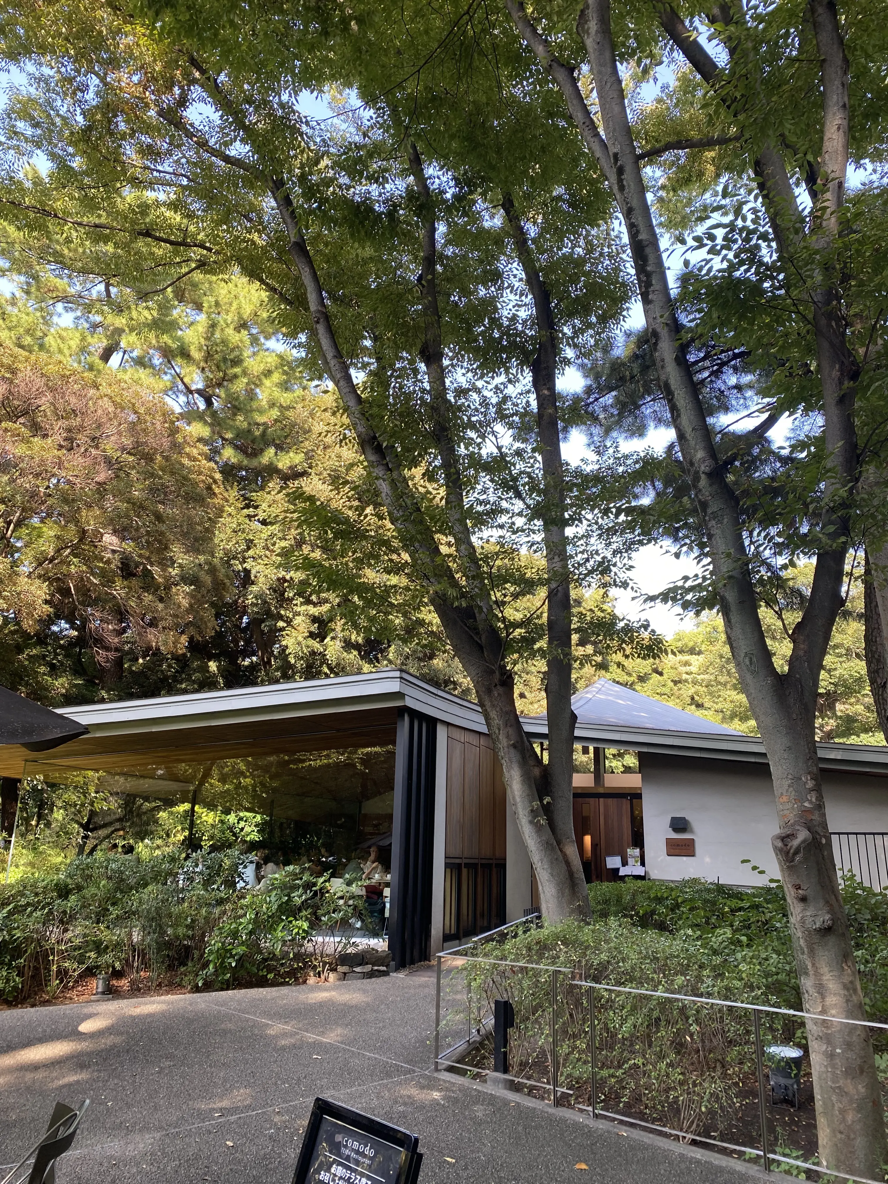 東京都庭園美術館に併設されたレストラン「TEIEN Restaurant comodo」の外観。緑に囲まれたモダンなガラス張りの建物。