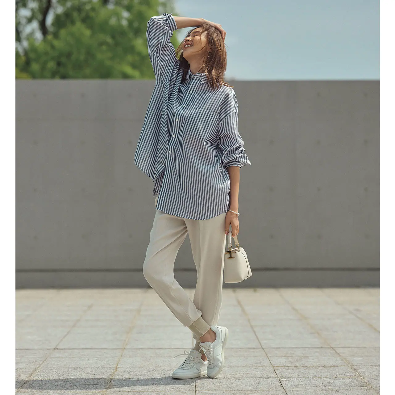 ブルーストライプシャツと白パンツのコーデを着たモデル・SHIHO