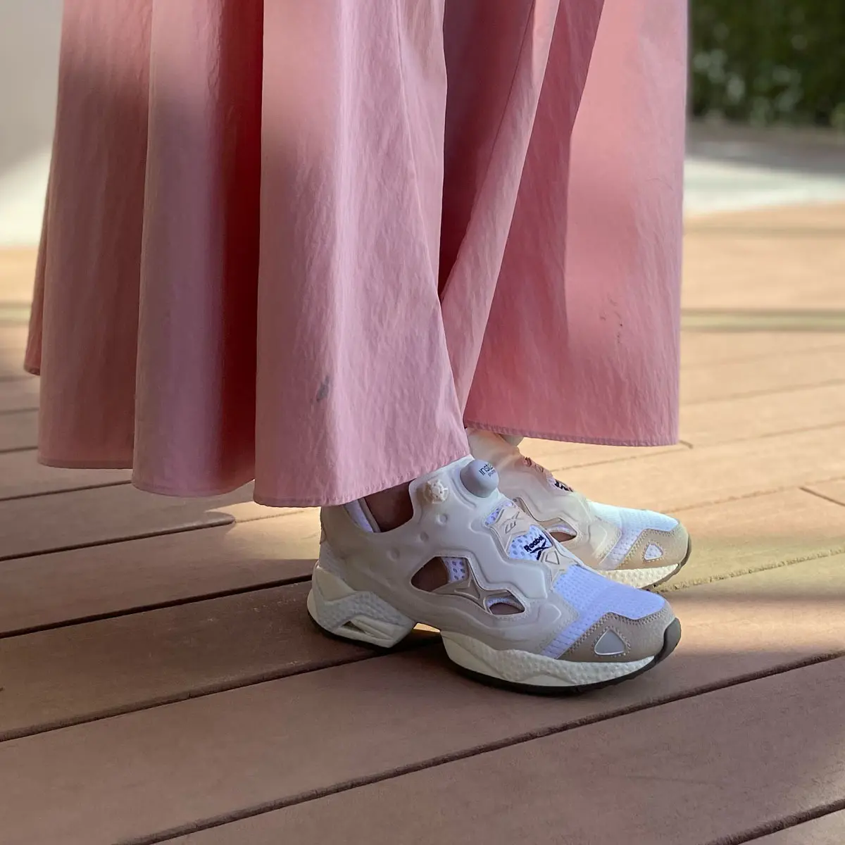 軽やかなピンクのロングスカートに合わせた白〜ベージュのトーンがきれいなスニーカーは、編集Nの推しの着用モデル！