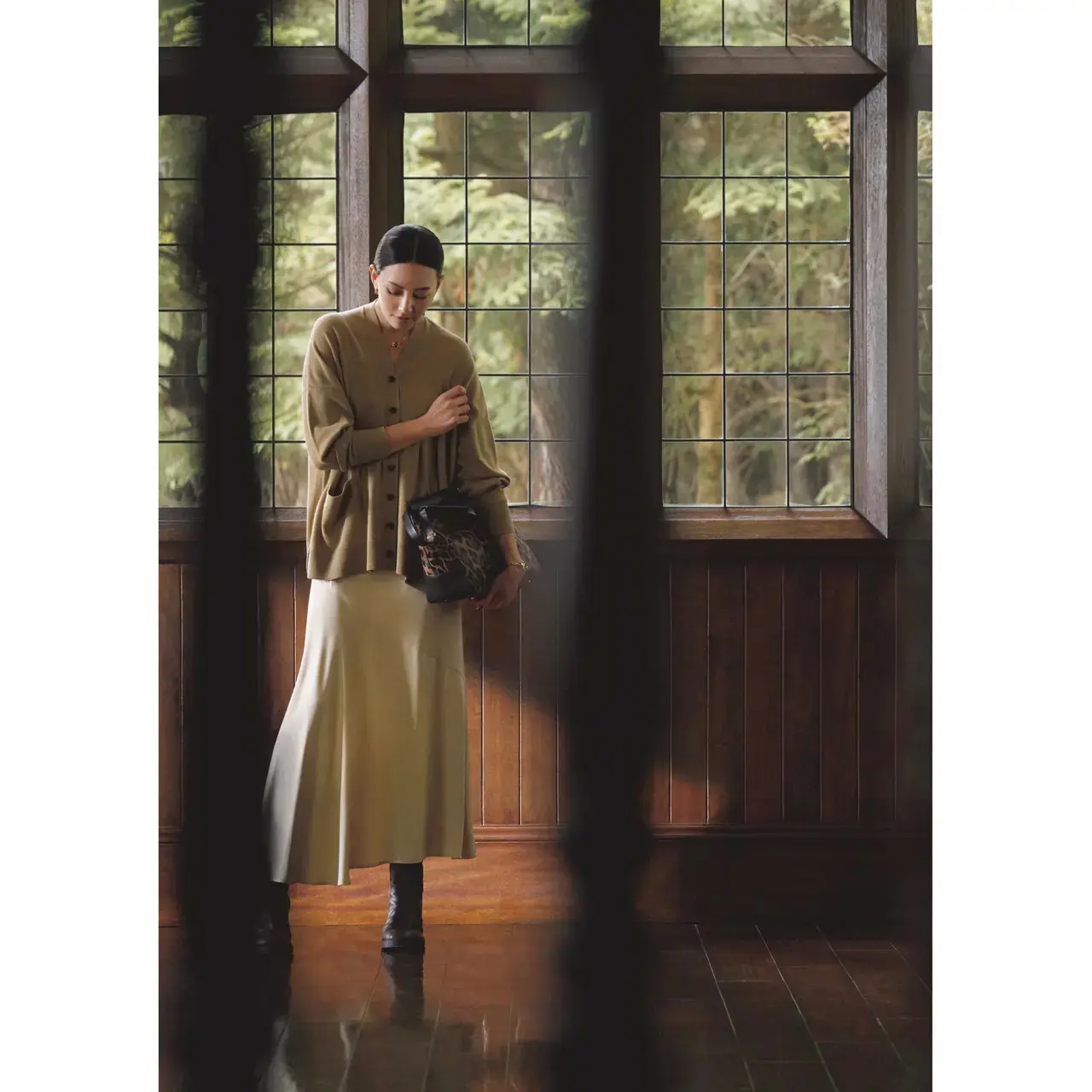 ふんわりニットカーディガンとツヤ感スカートの質感の違いがワントーンコーデに洒落たメリハリをプラス。