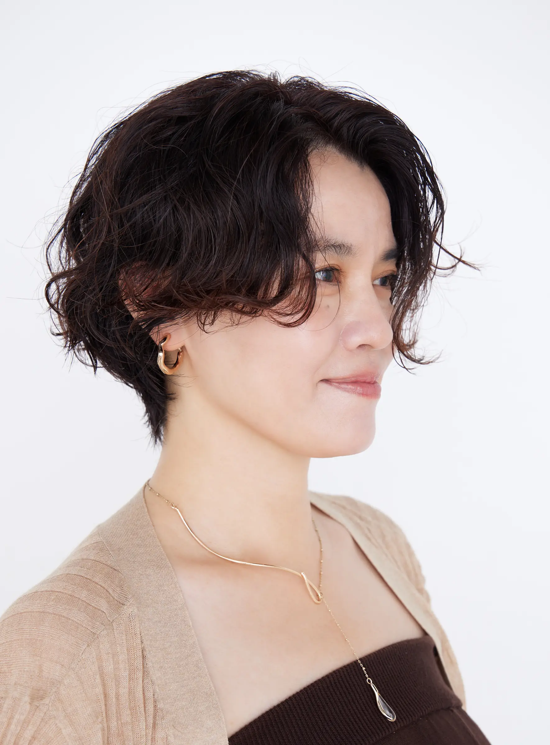 Webエクラ 40代50代　髪型　横から見たうねりにパーマを足したショートヘアスタイル