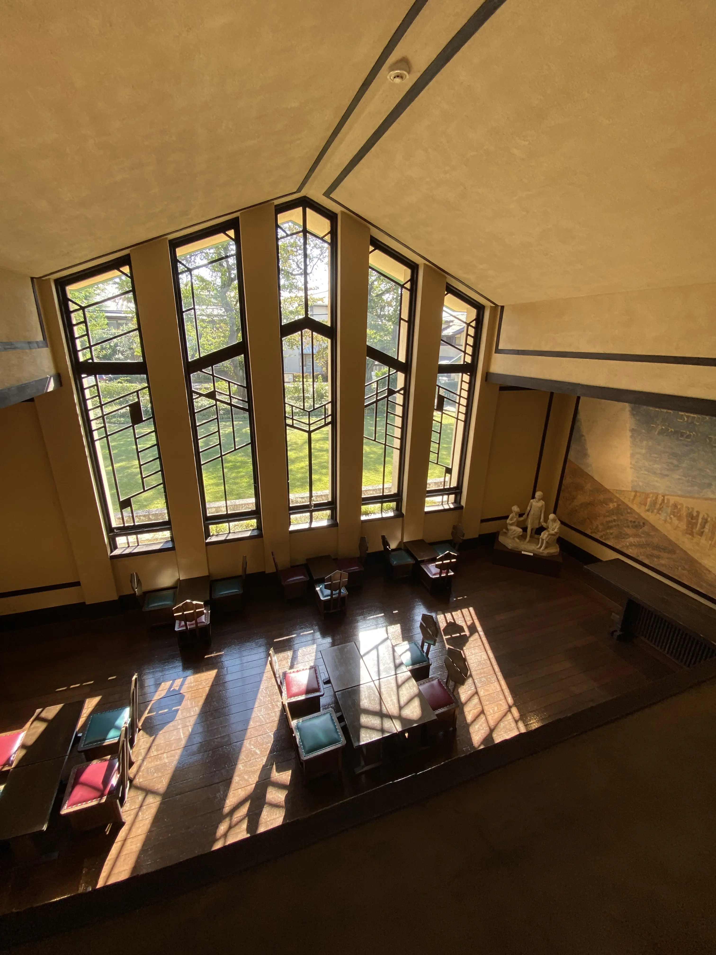 自由学園明日館の吹き抜けから見たラウンジと窓。幻想的な光と影のコントラスト。
