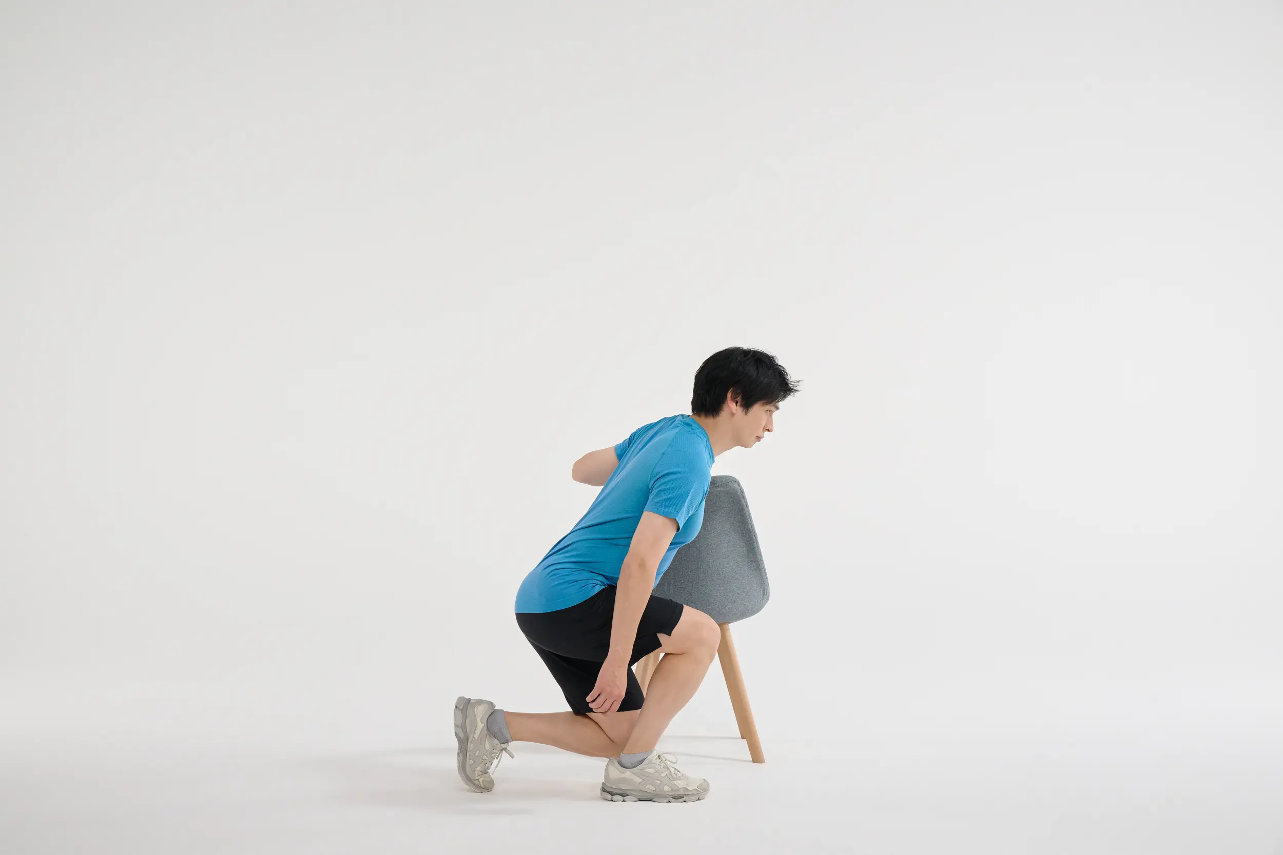 ②　両膝を曲げて、お尻を軽く引く。このとき左膝が真下に降りるようにしゃがみ、膝が床につくギリギリまで下ろす。次に、右のかかとで床を押して、裏ももとお尻の筋肉を使って立ち上がる。このとき右膝は伸び切らないように。①②を10回×3セット。終わったら前後の足を入れ替えて同様に。