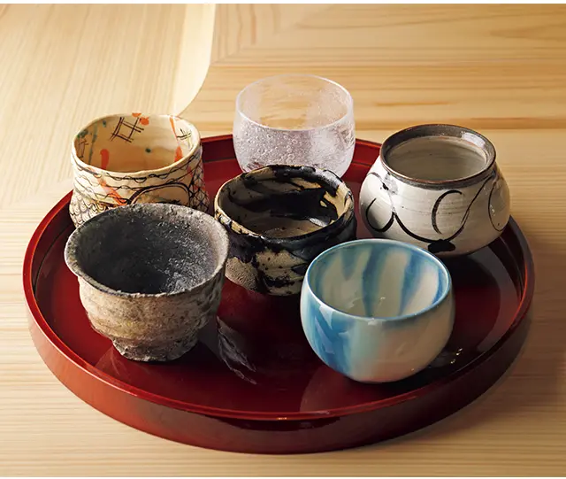 日本酒はすべて、機能にすぐれ、芸術性も高い行 天氏セレクトの酒椀で供される