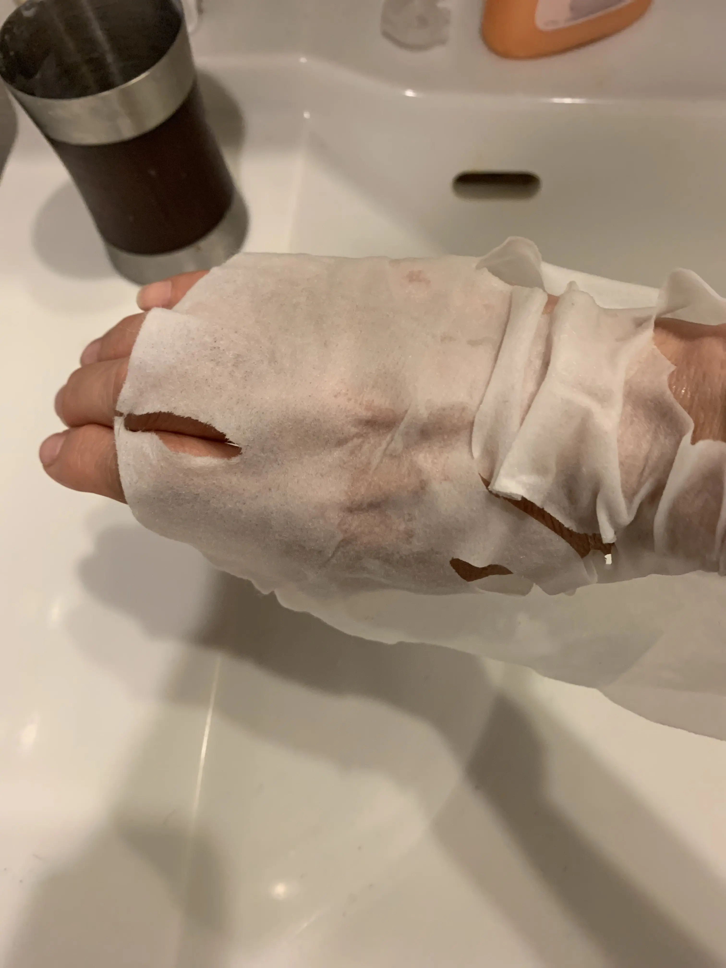 水分が残ったシートマスクを手に巻く