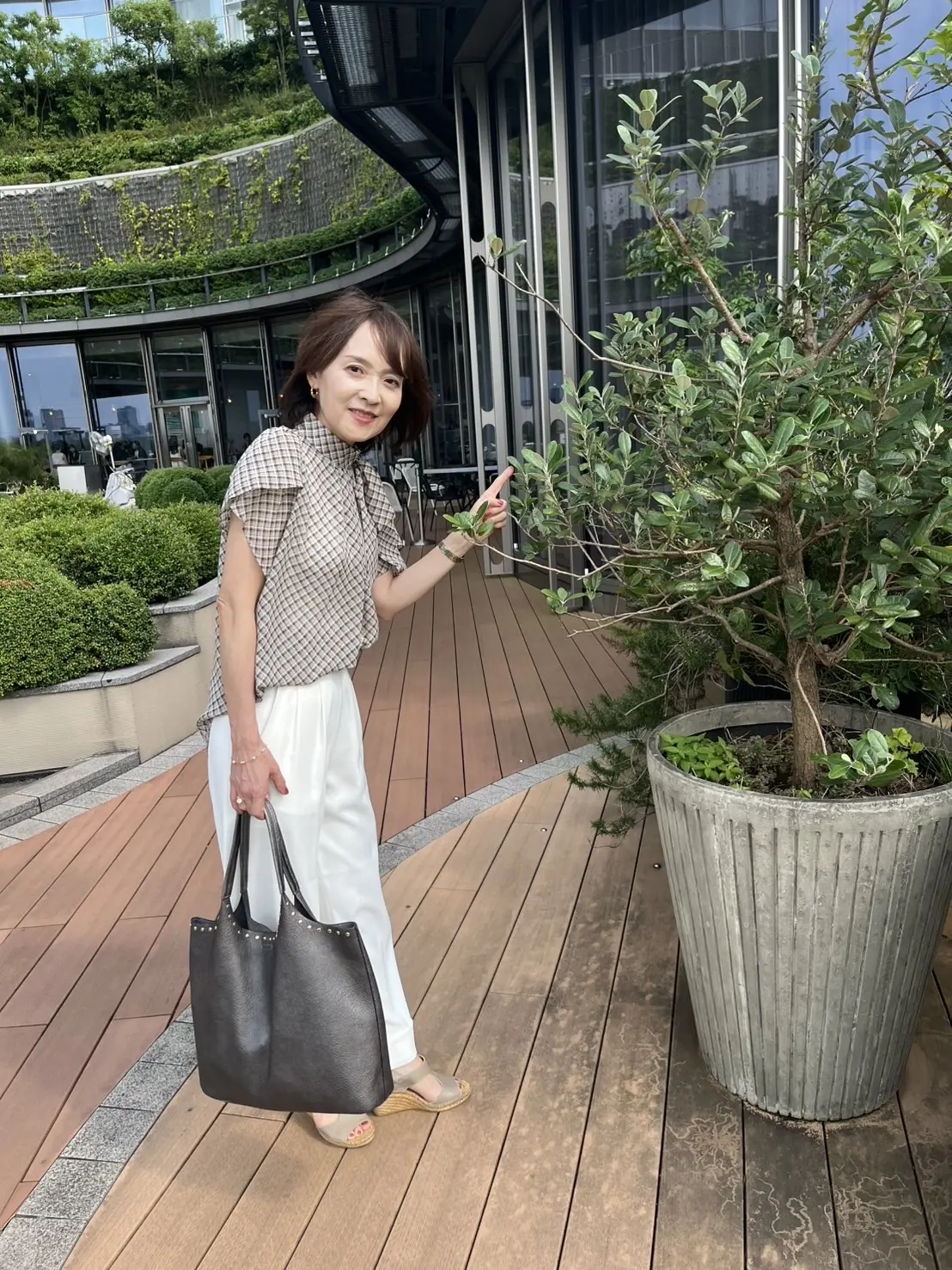 東京ミッドタウン日比谷6階のオープンスペースで写真撮影をしてほほ笑む女性