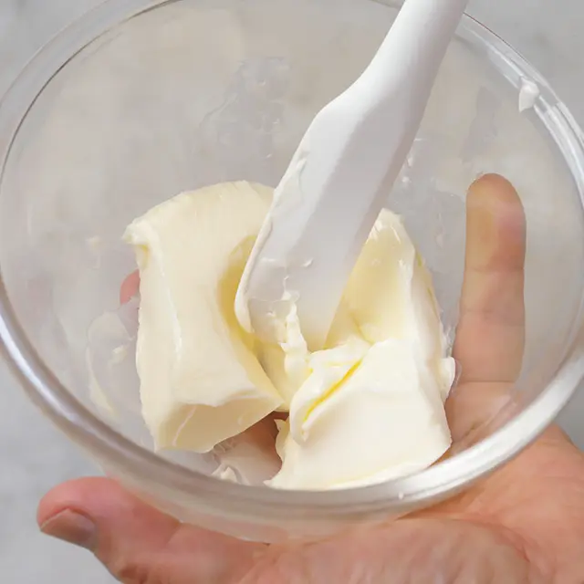 バターを耐熱容器に入れ、電子レンジ（500 W）で上下返して各10秒かけて軟らかくし、 クリーム状に練る。