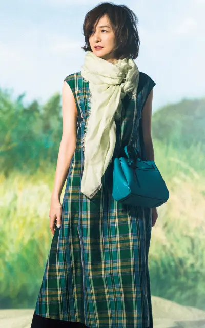 鮮やかなグリーンのバッグを持つ富岡佳子