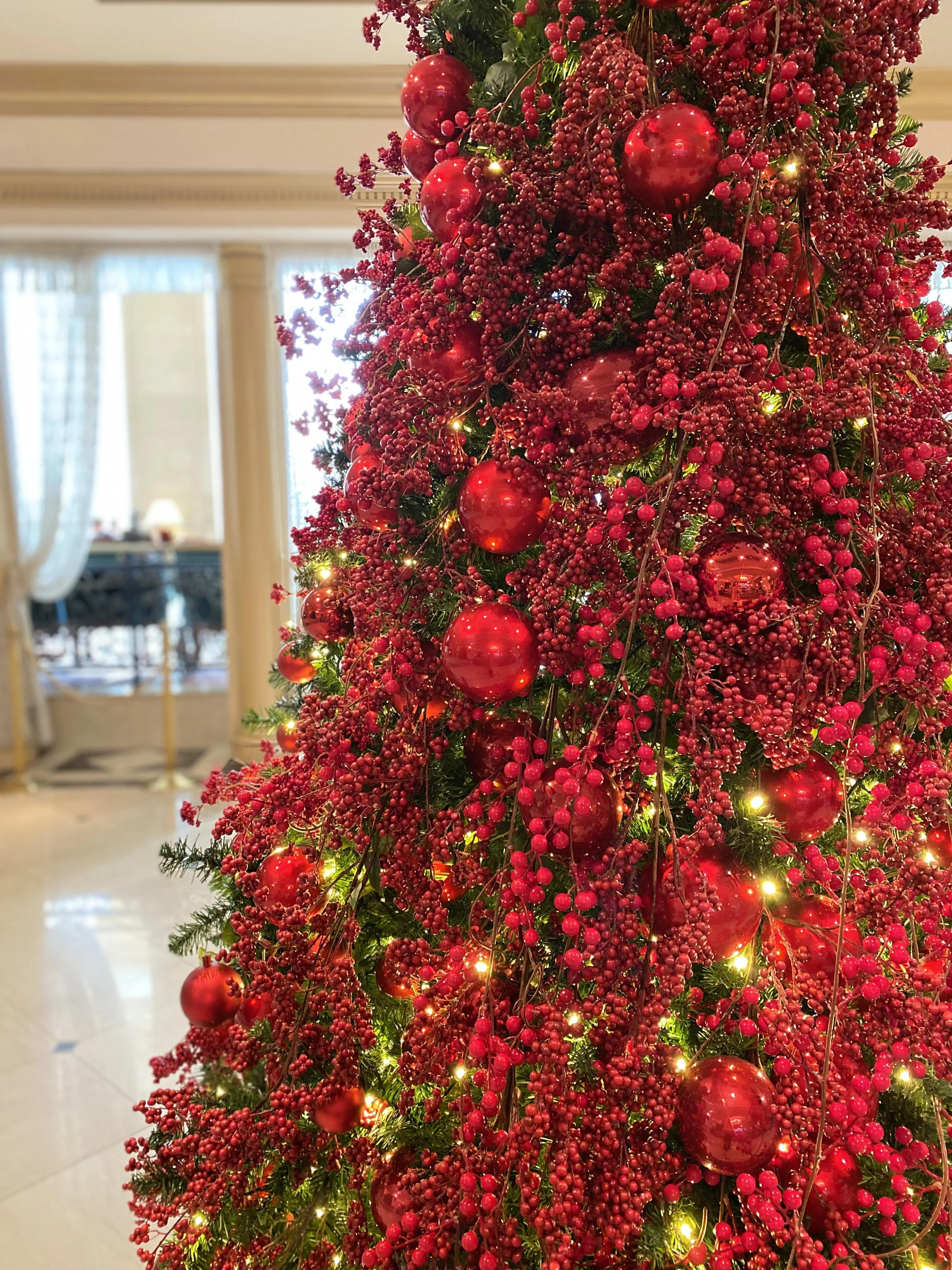 リーガロイヤルホテル東京のロビーに飾られた赤い実のクリスマスツリー。冬の早稲田エリアで話題のホテル装飾。華やかな赤のオーナメントとイルミネーションが映えるクリスマスツリー。