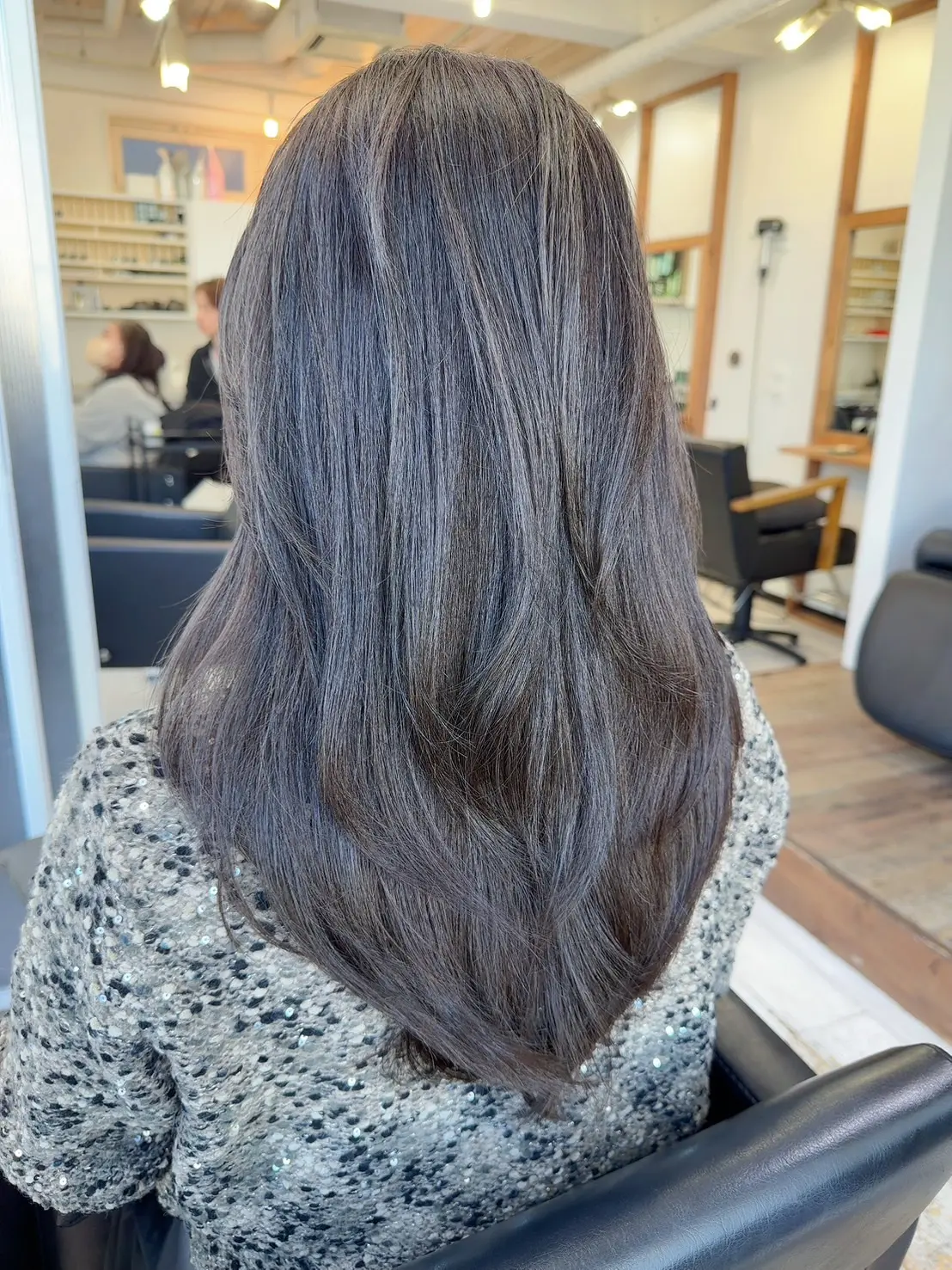 50代女性のロングヘア後ろ姿。ハイレイヤーで動きを出した暗めカラーのロングヘアスタイル｜ツヤ感のある大人ロング｜Heart’s 原宿ヤハギ